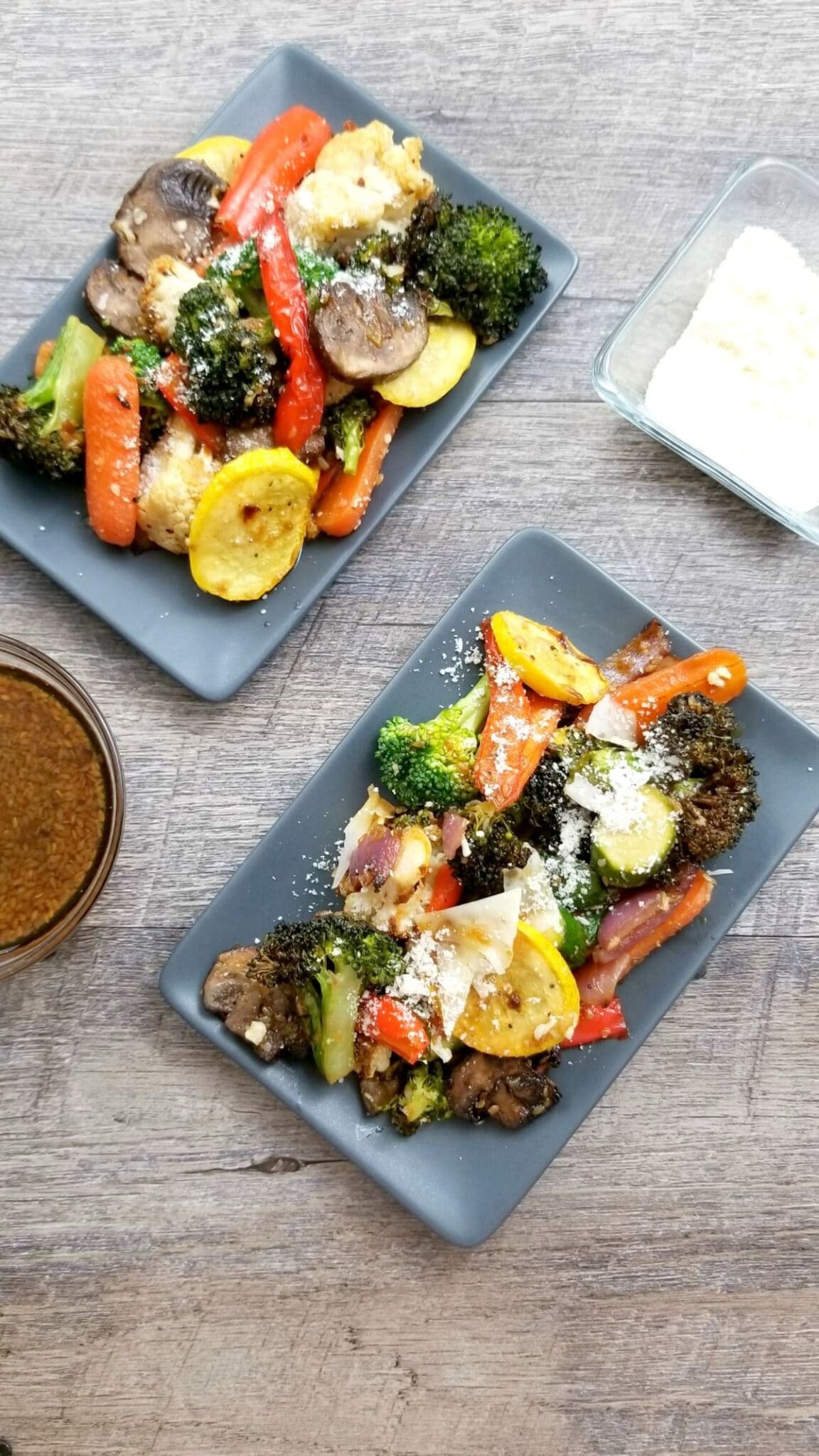 Air Fryer Roasted Vegetables on two plates topped with parmesan cheese 