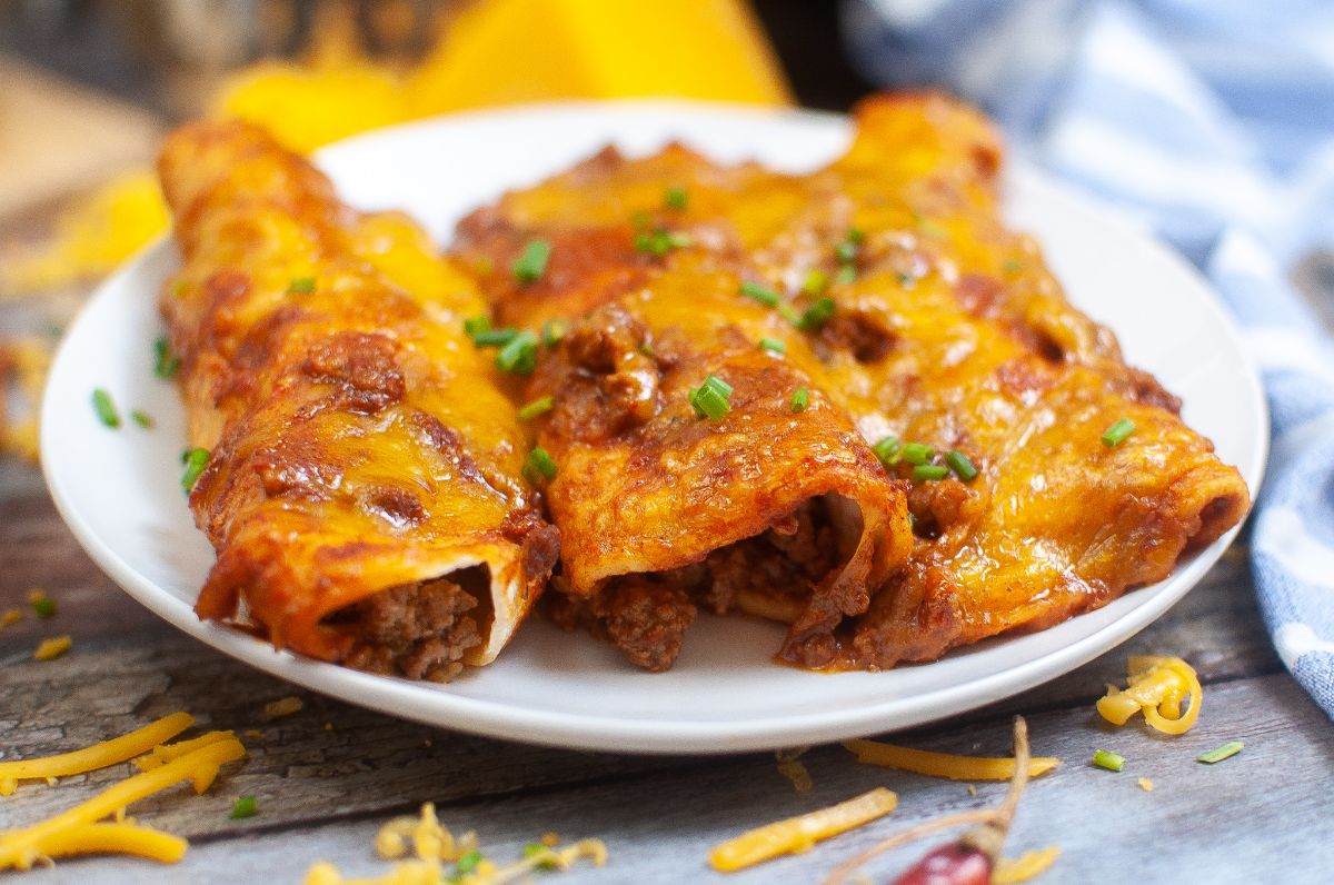 Air Fryer Enchiladas on a plate and garnished with chopped spring onion