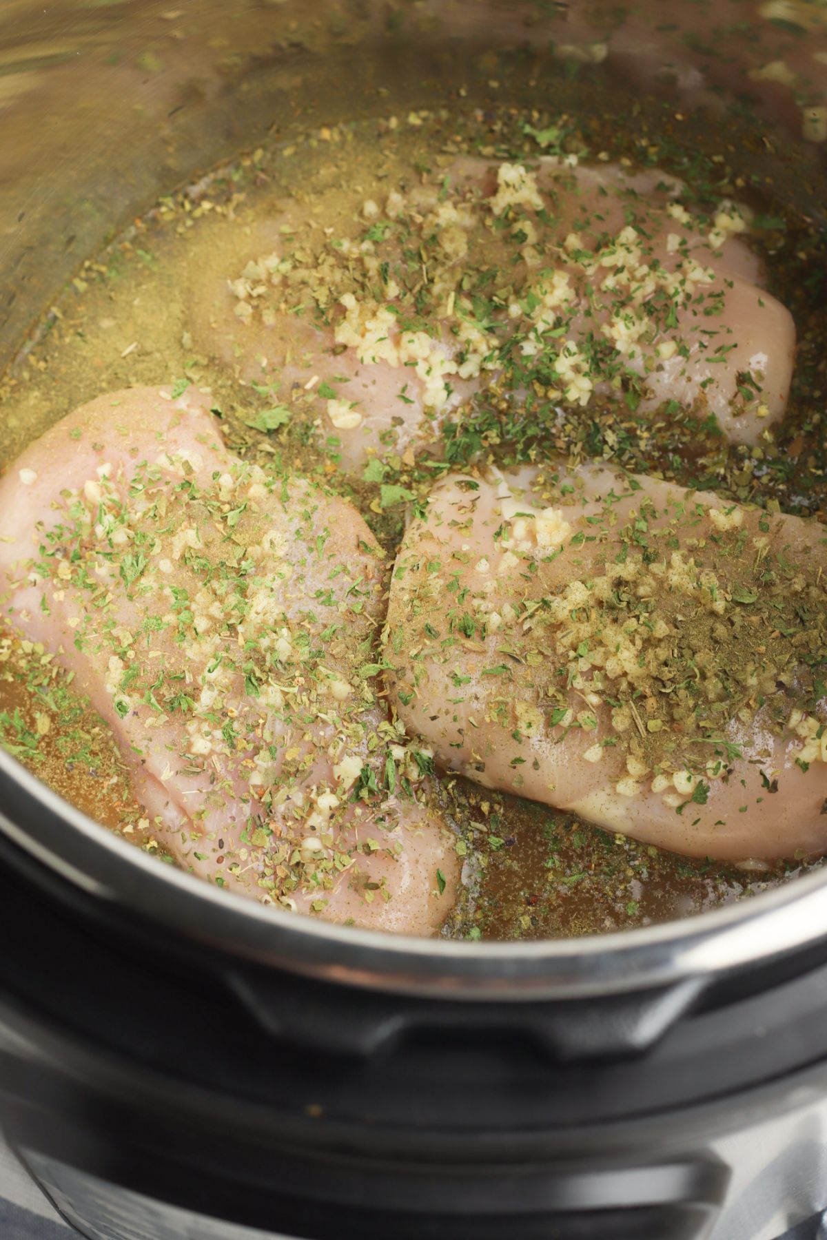 rice, Chicken stock, seasonings and chicken breasts inside the Instant Pot