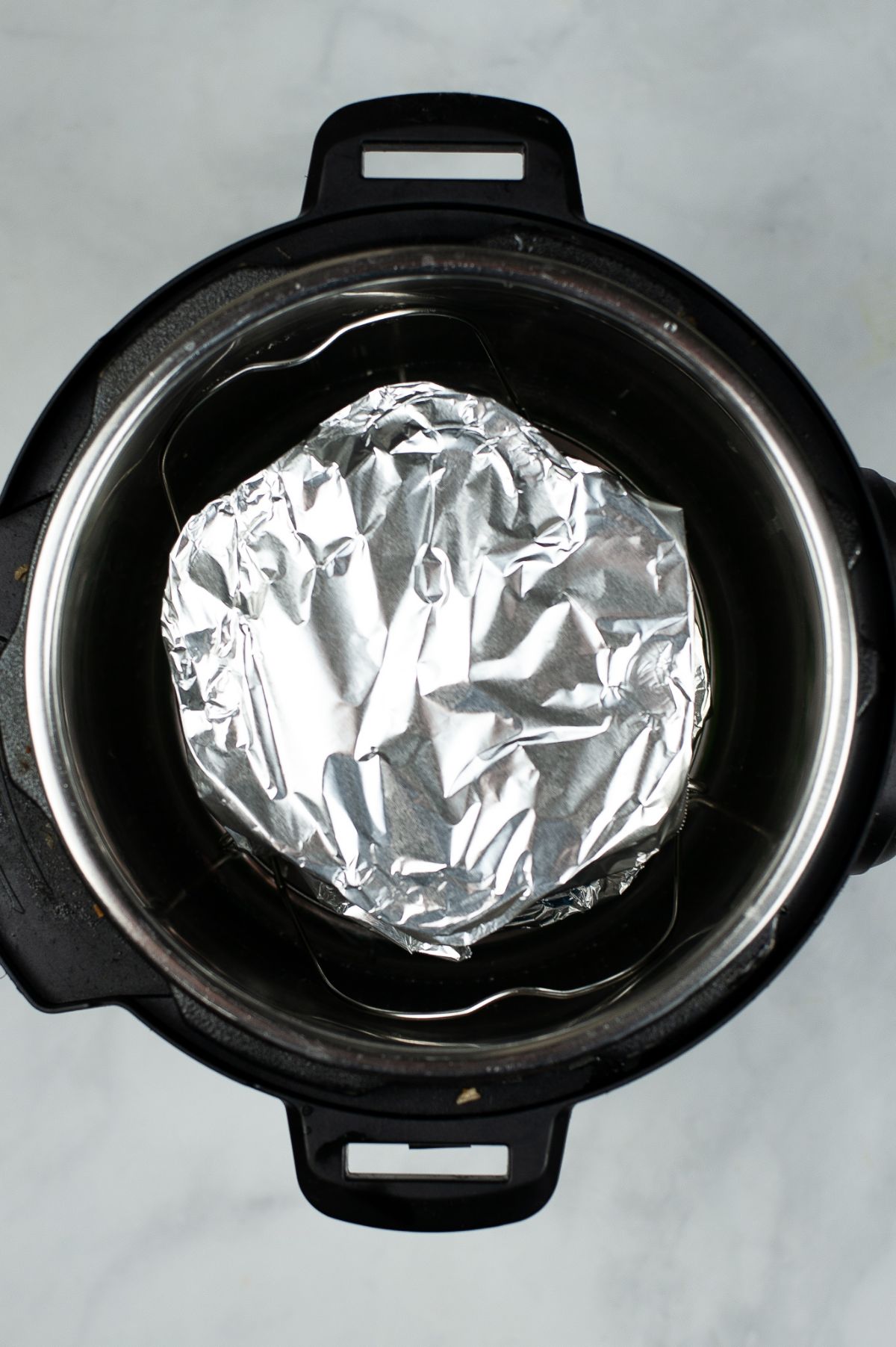 Filled egg mold covered with foil in an instant pot