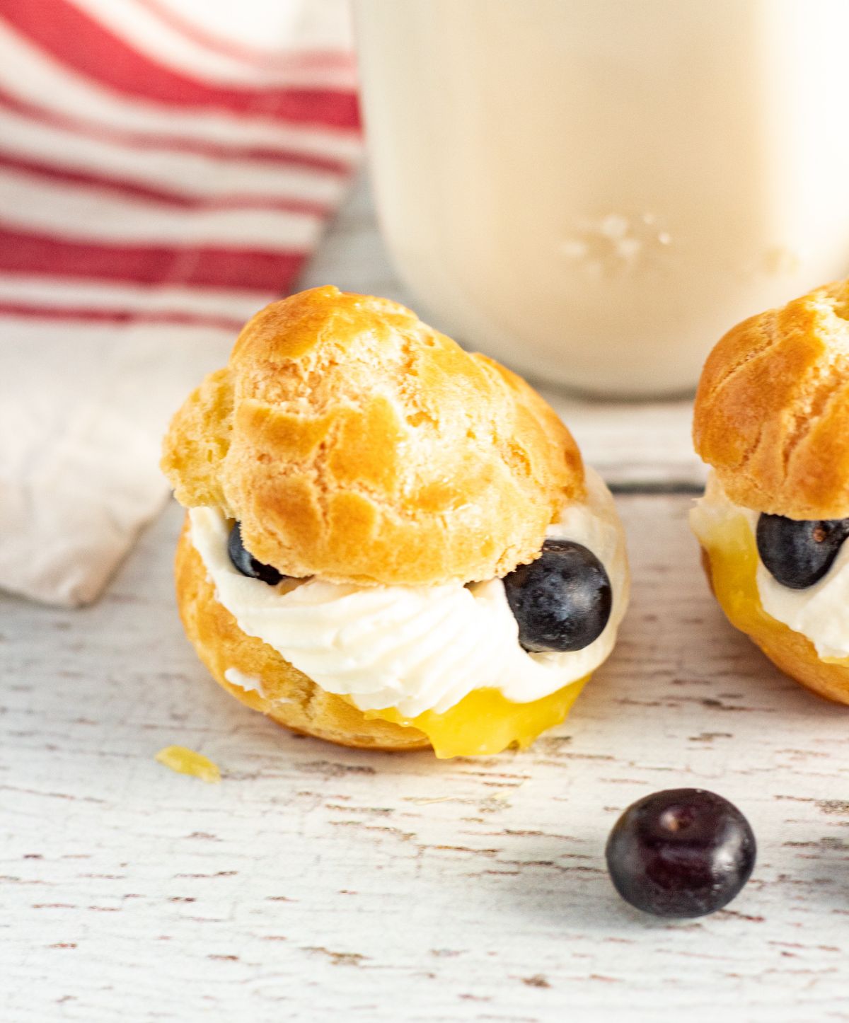 a closeup of two Lemon Cream Puffs With Fresh Blueberries 
