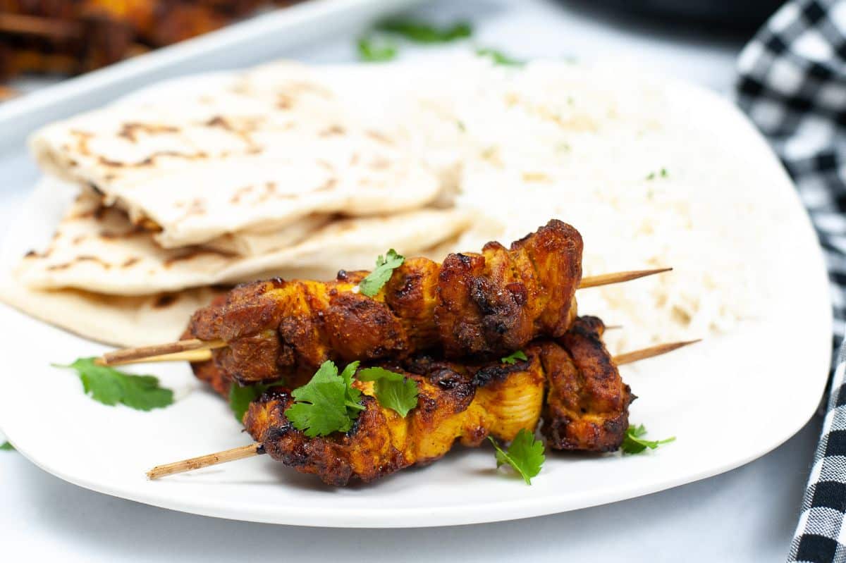 Air Fryer Tandoori Chicken on a plate with Naan bread and basmati rice garnished with parsley 