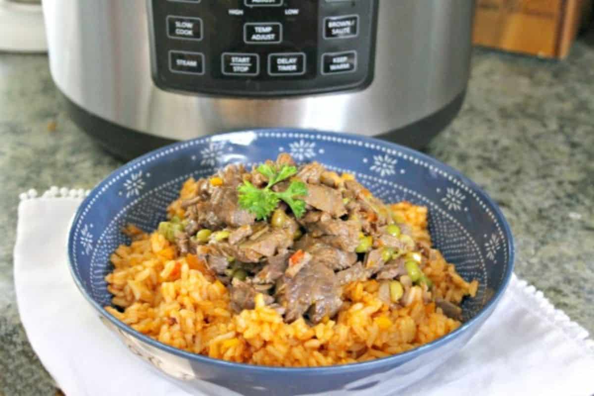 Instant Pot Ropa Vieja in a blue bowl with an instant pot in the background
