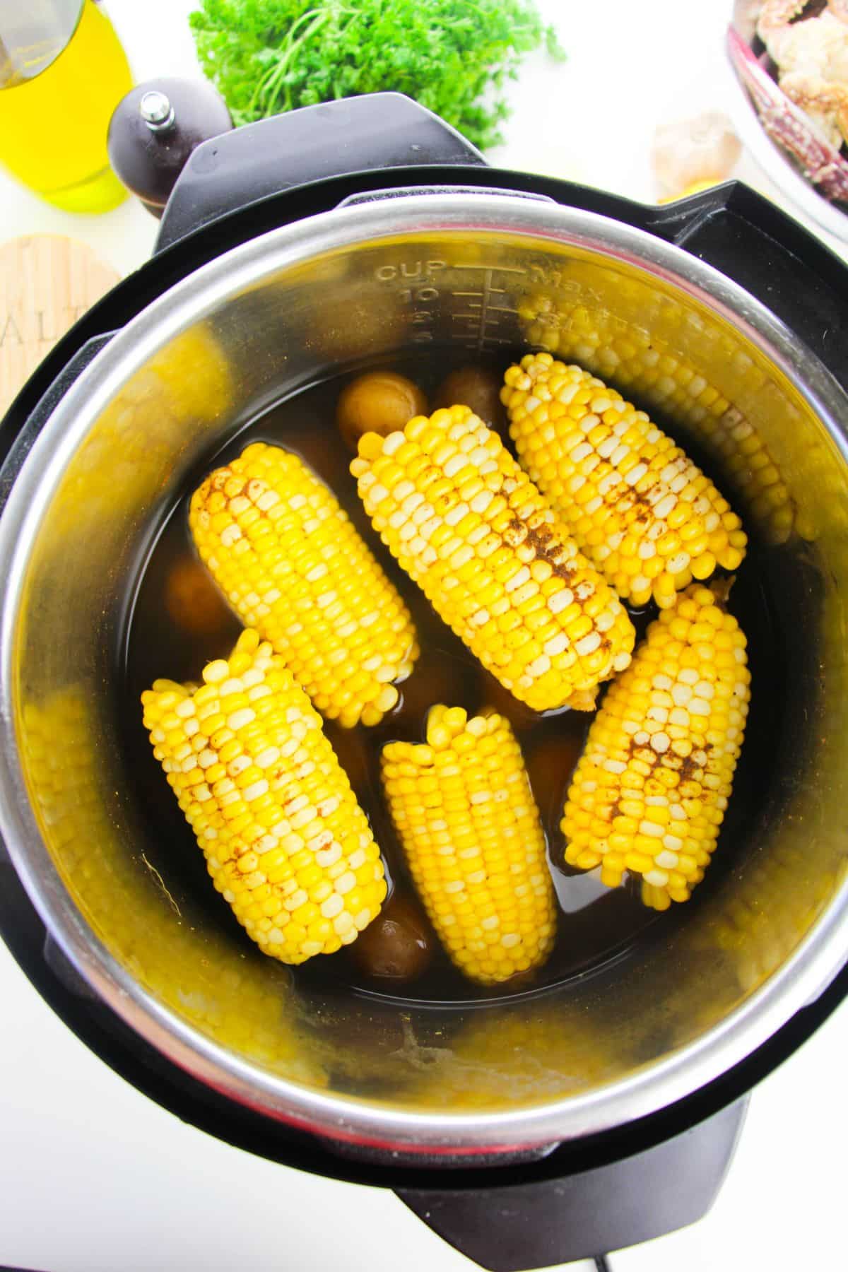 Corn and baby potatoes inside the Instant Pot seasoned with Old Seasoning and added water  