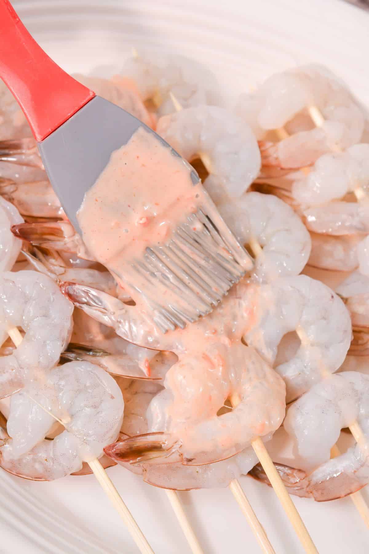 a brush being used to put sauce on the shrimp