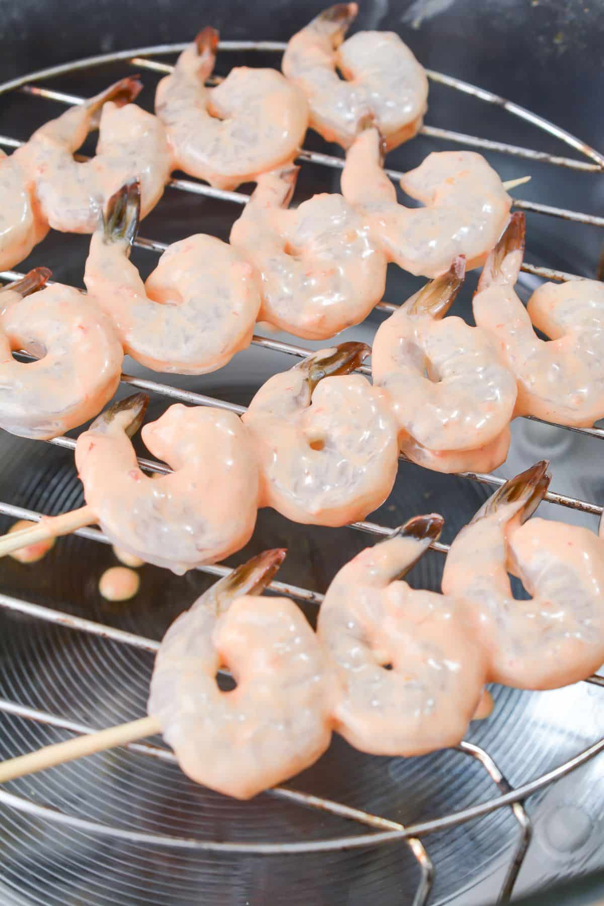 Shrimp with sauce on wooden skewers placed in an Air fryer 