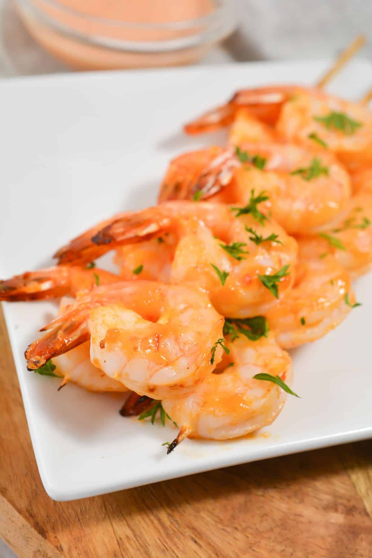 Keto bang bang shrimp on a plate, garnished with chopped parsley
