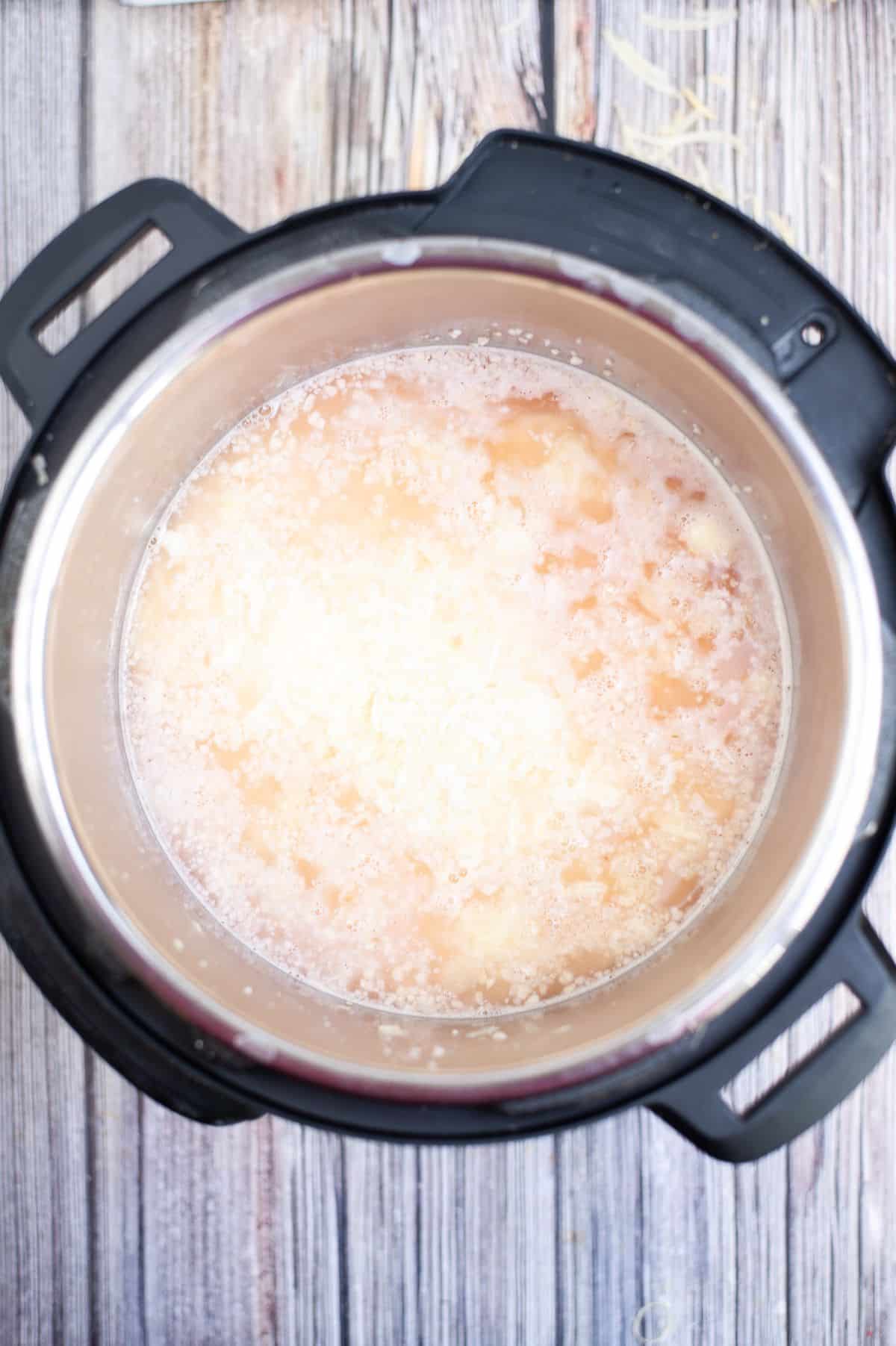 Wine, water, garlic, lemon juice, and cheese inside the instant pot