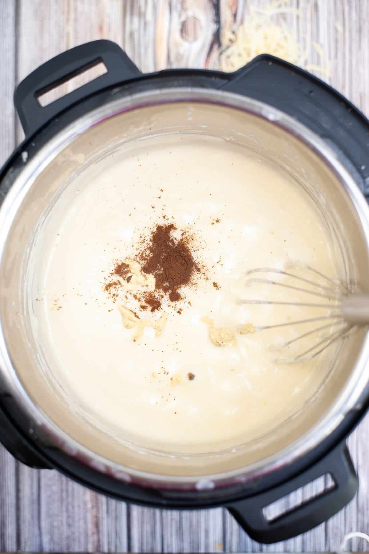Melted swiss cheese seasoned with nutmeg and mustard inside the instant pot