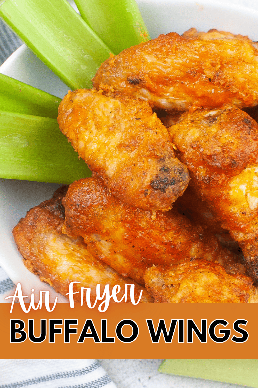 a closeup of Air Fryer Buffalo Wings in a large bowl next to celery stalks with title text reading Air Fryer Buffalo Wings