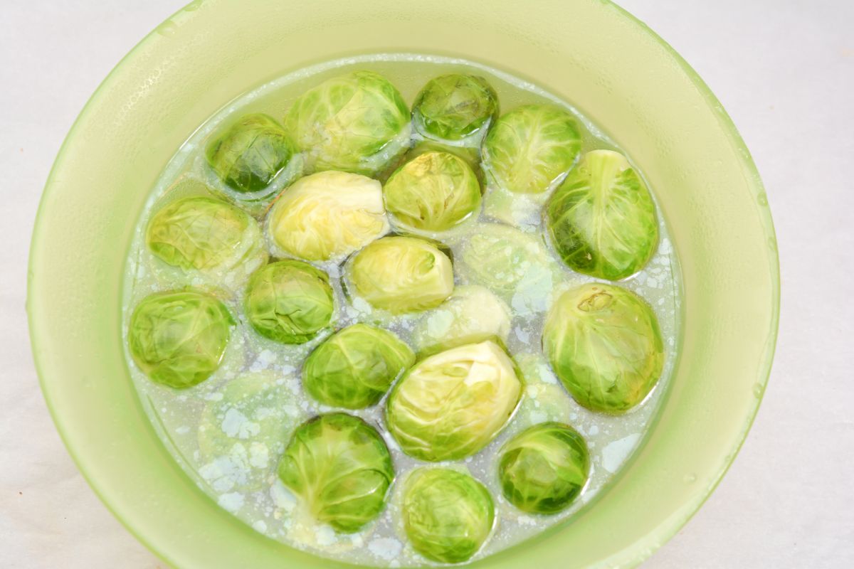 Brussel Sprouts and water in a microwave-safe bowl 