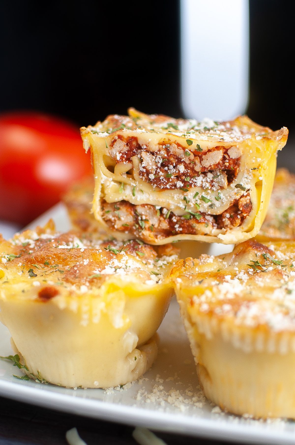 a closeup of an Air Fryer Lasagna Cup cut in half stacked on more lasagna on a plate