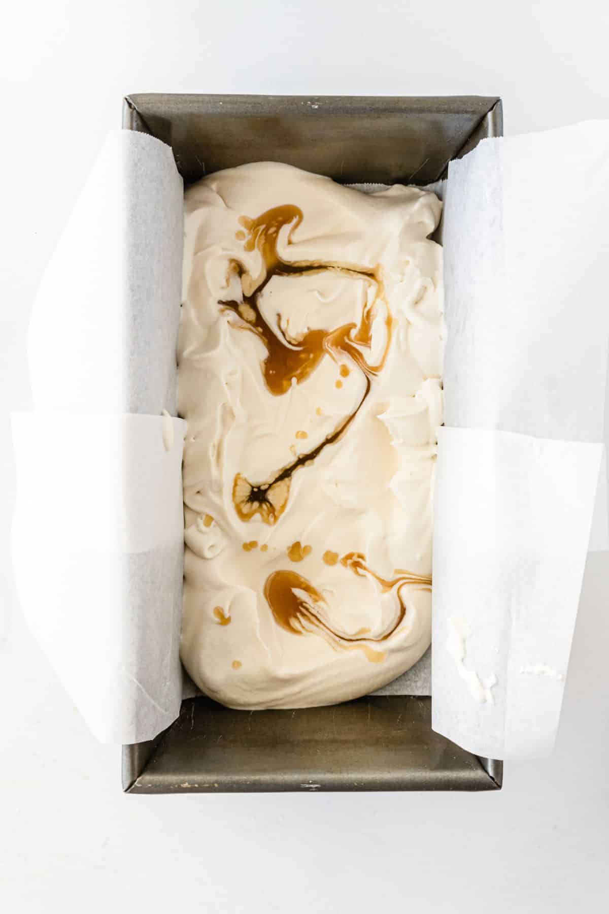 the cooled butterscotch sauce drizzled over the top of the ice cream mixture. 