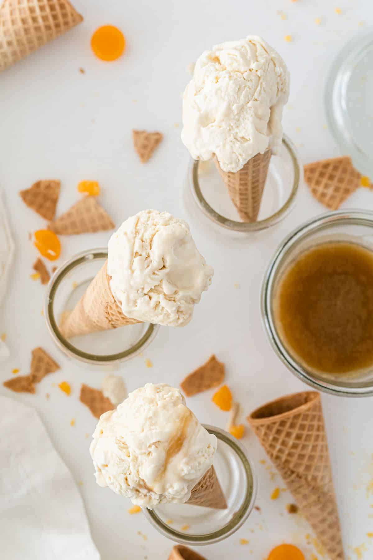 Butterbeer Ice Cream cones in glass jars next to ice cream cones and caramel candy 