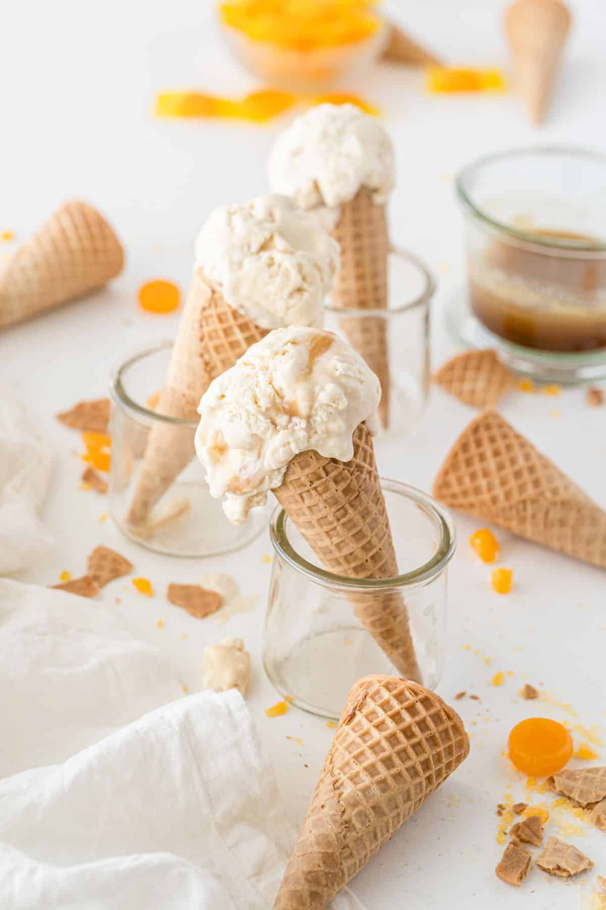 Butterbeer Ice Cream cones in glass jars next to ice cream cones and caramel candy 