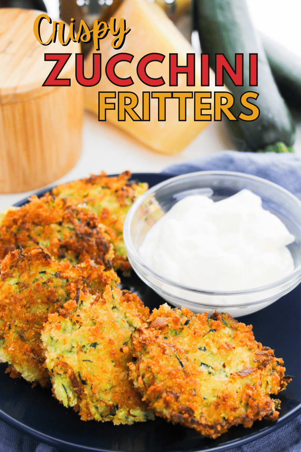 zucchini fritters and a glass bowl of sauce on a blue plate with title text reading Crispy Zucchini Fritters