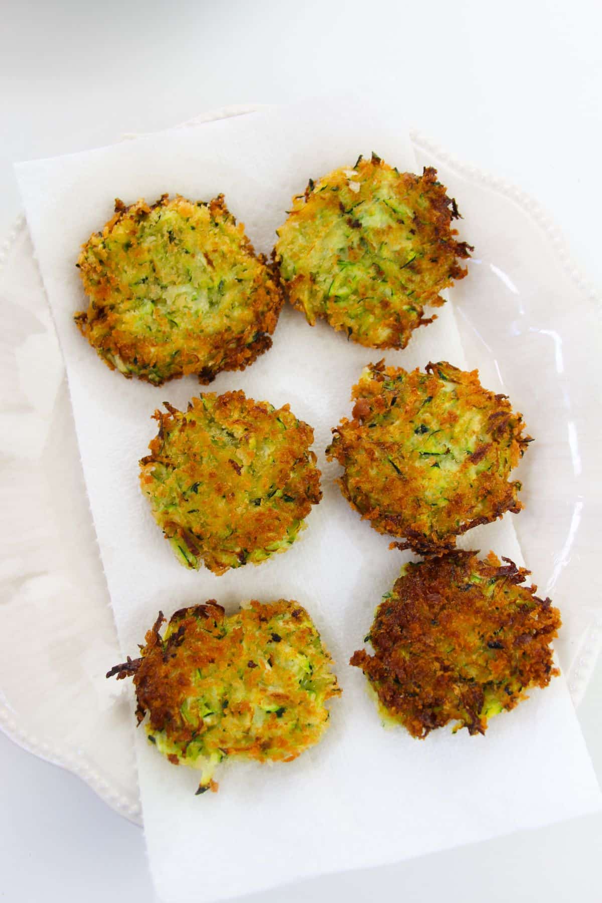 Crispy Zucchini Fritters on a paper towel on a plate