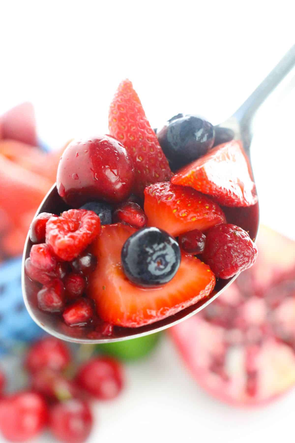 a closeup of Fruit Berry Salad with Honey Lime Dressing on a spoon