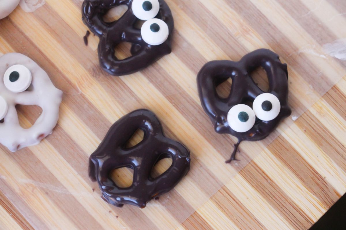 Black candy-coated pretzels with candy eyes.