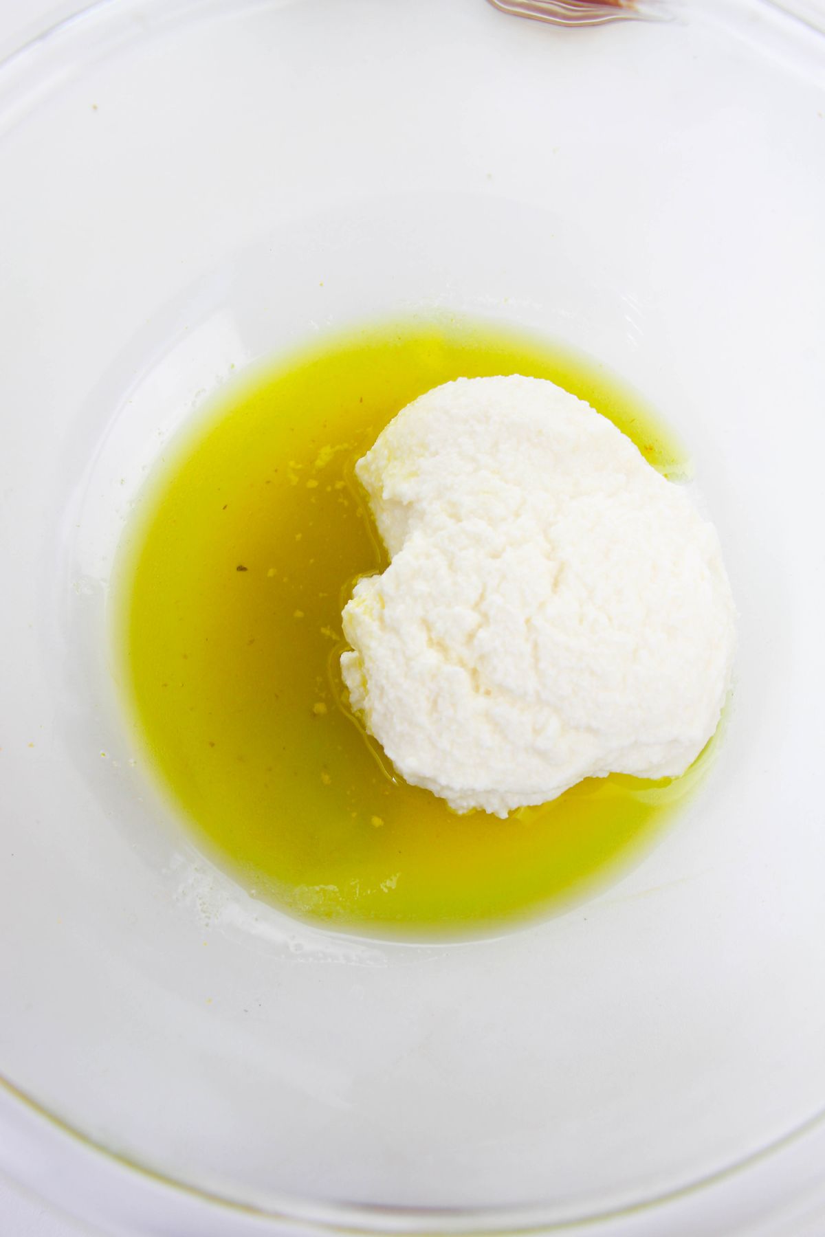 Oil and ricotta cheese in a small glass bowl