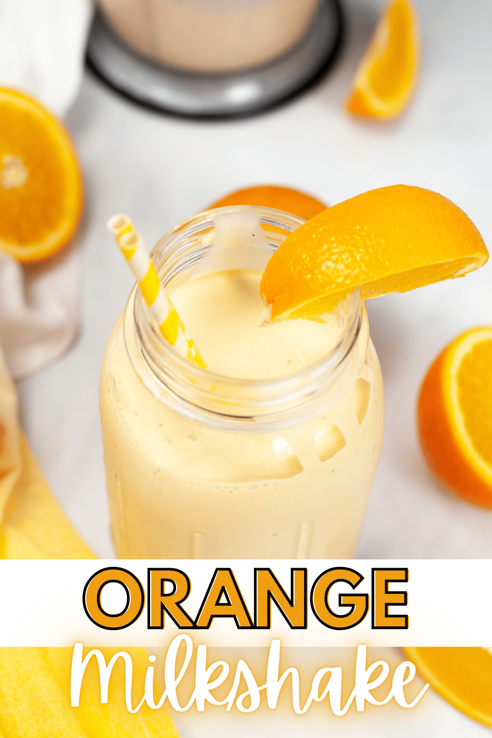 a closeup of an Orange Milkshake in a jar with straw and orange slice and surrounded by oranges and halved oranges with title text reading Orange Milkshake