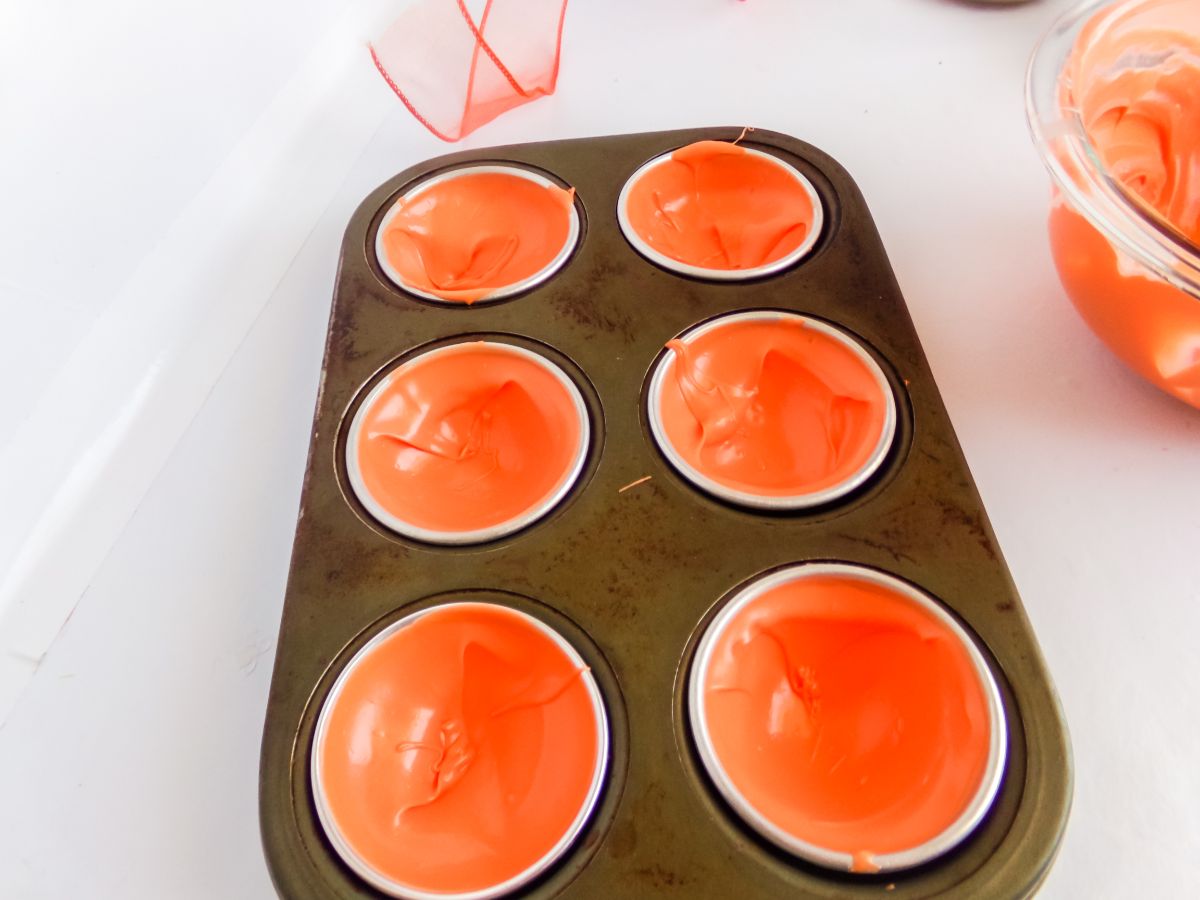 Orange melted candy in bomb molds.