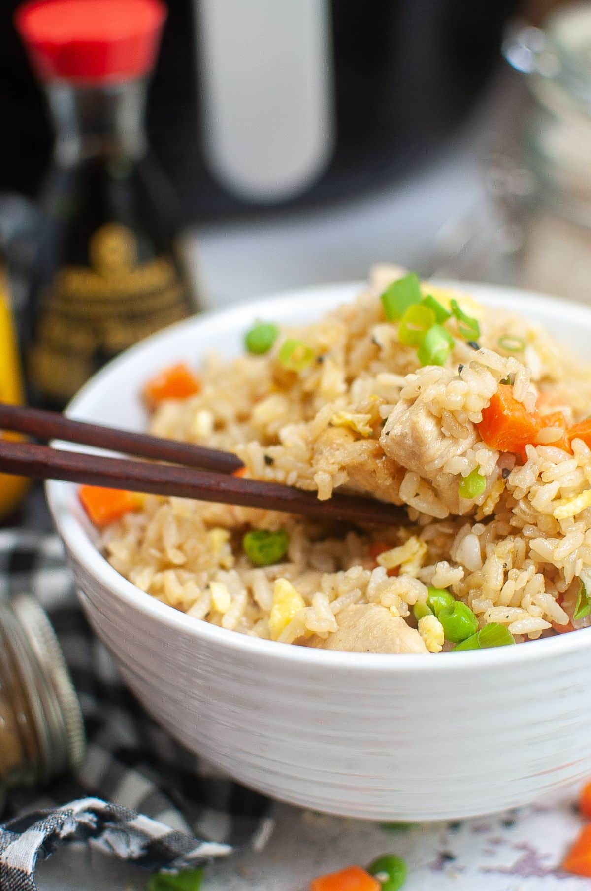 Air Fryer Chicken Fried Rice in a serving bowl with chopsticks dipping into the fried rice. 