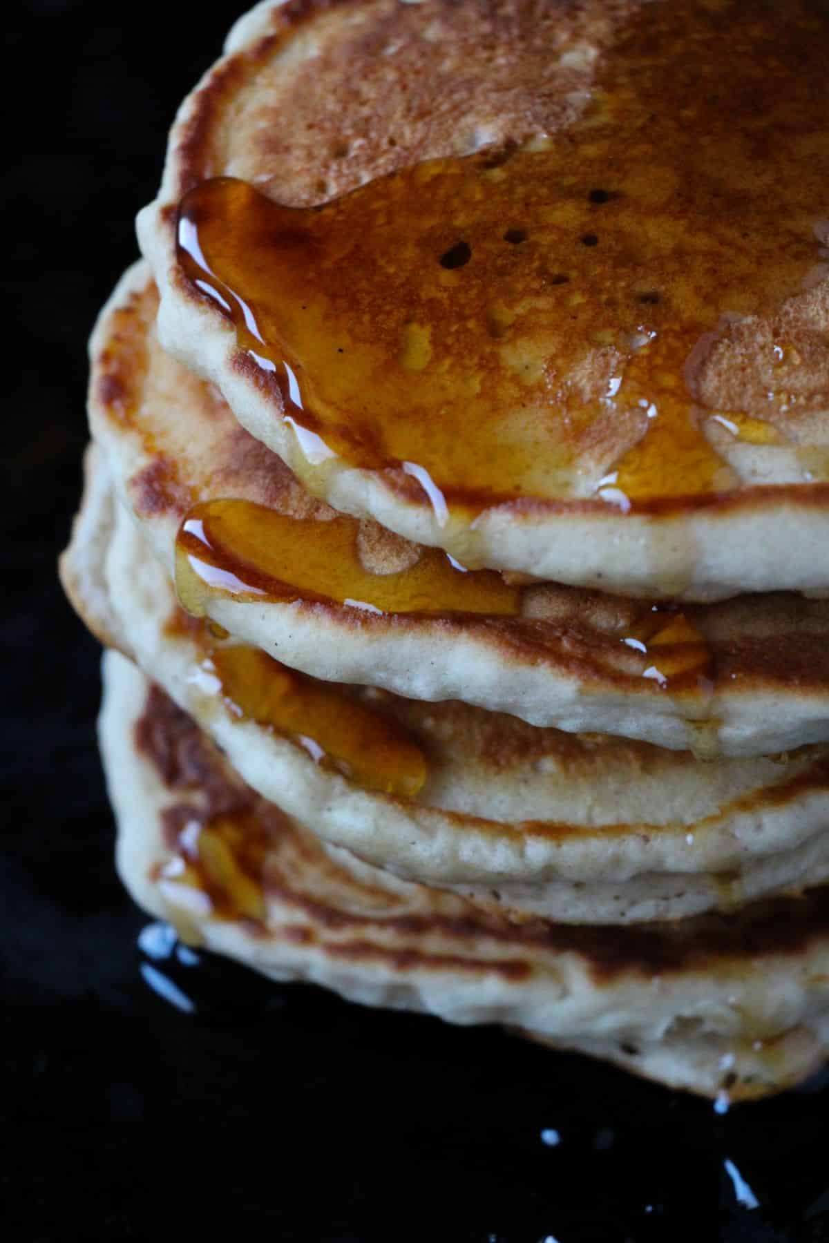 a stack of Eggnog Pancakes topped with maple syrup.