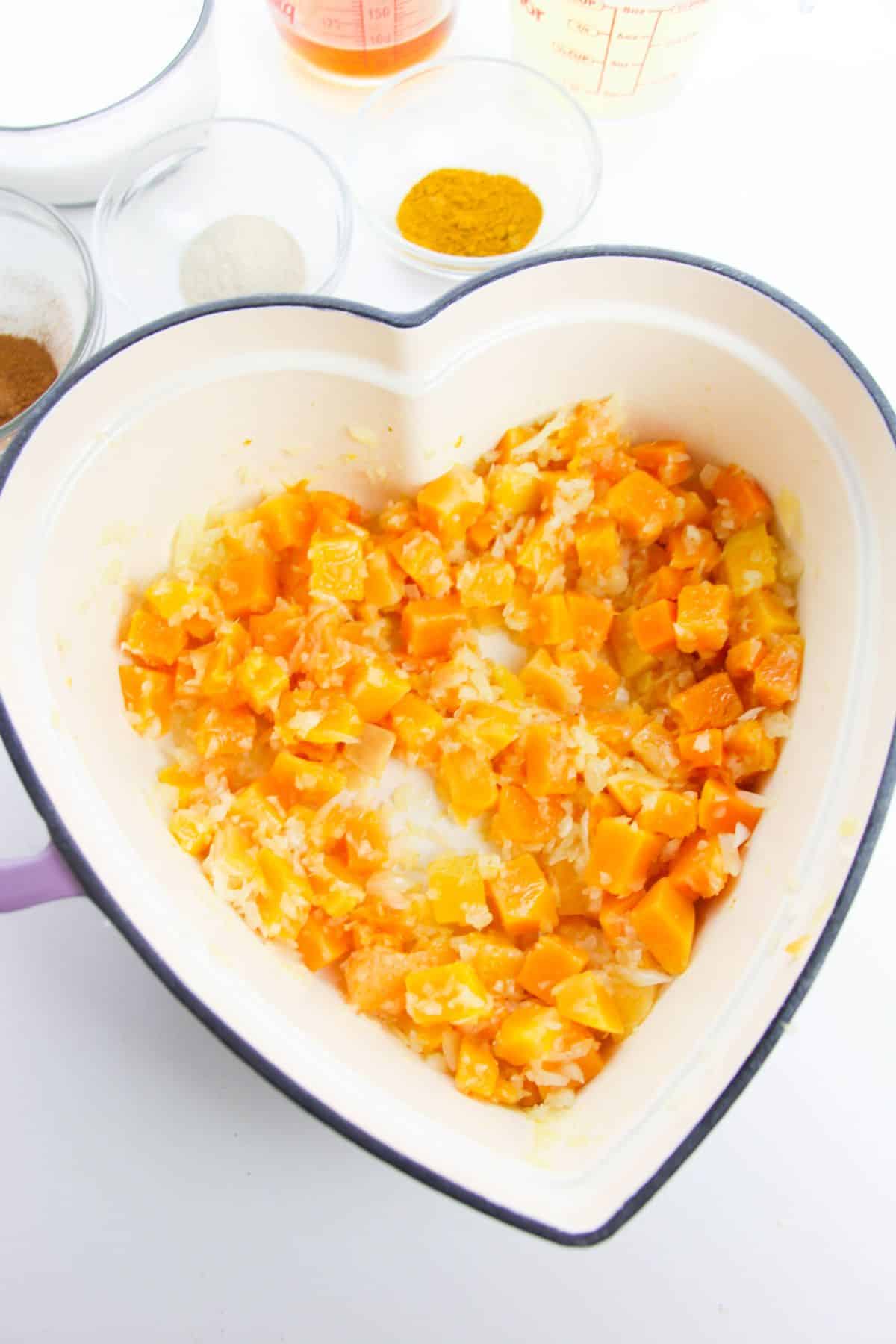 Onion and butternut squash in a large heart-shaped pot.