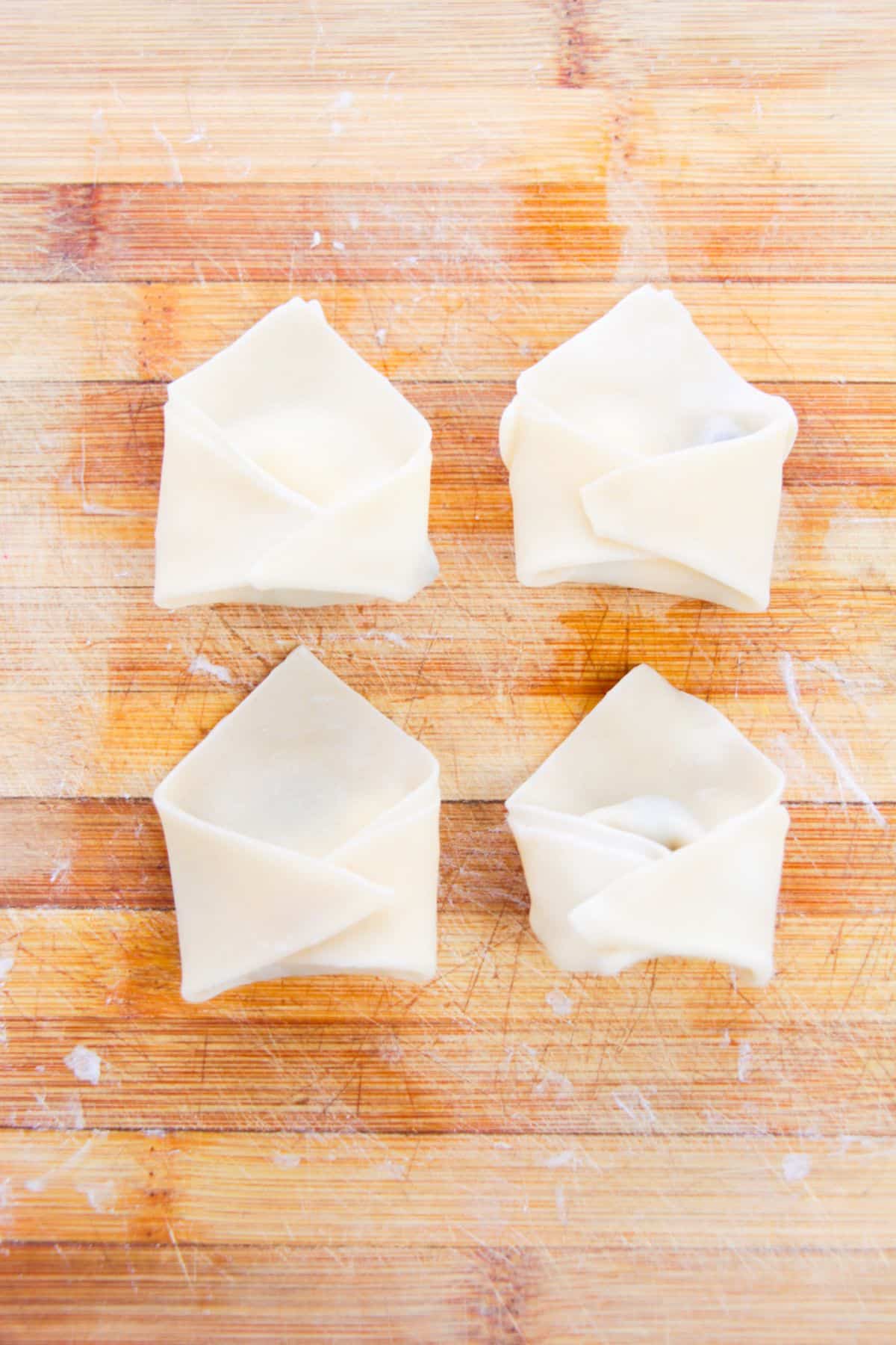 folded Wonton wrappers with chocolate chips and marshmallows inside. 