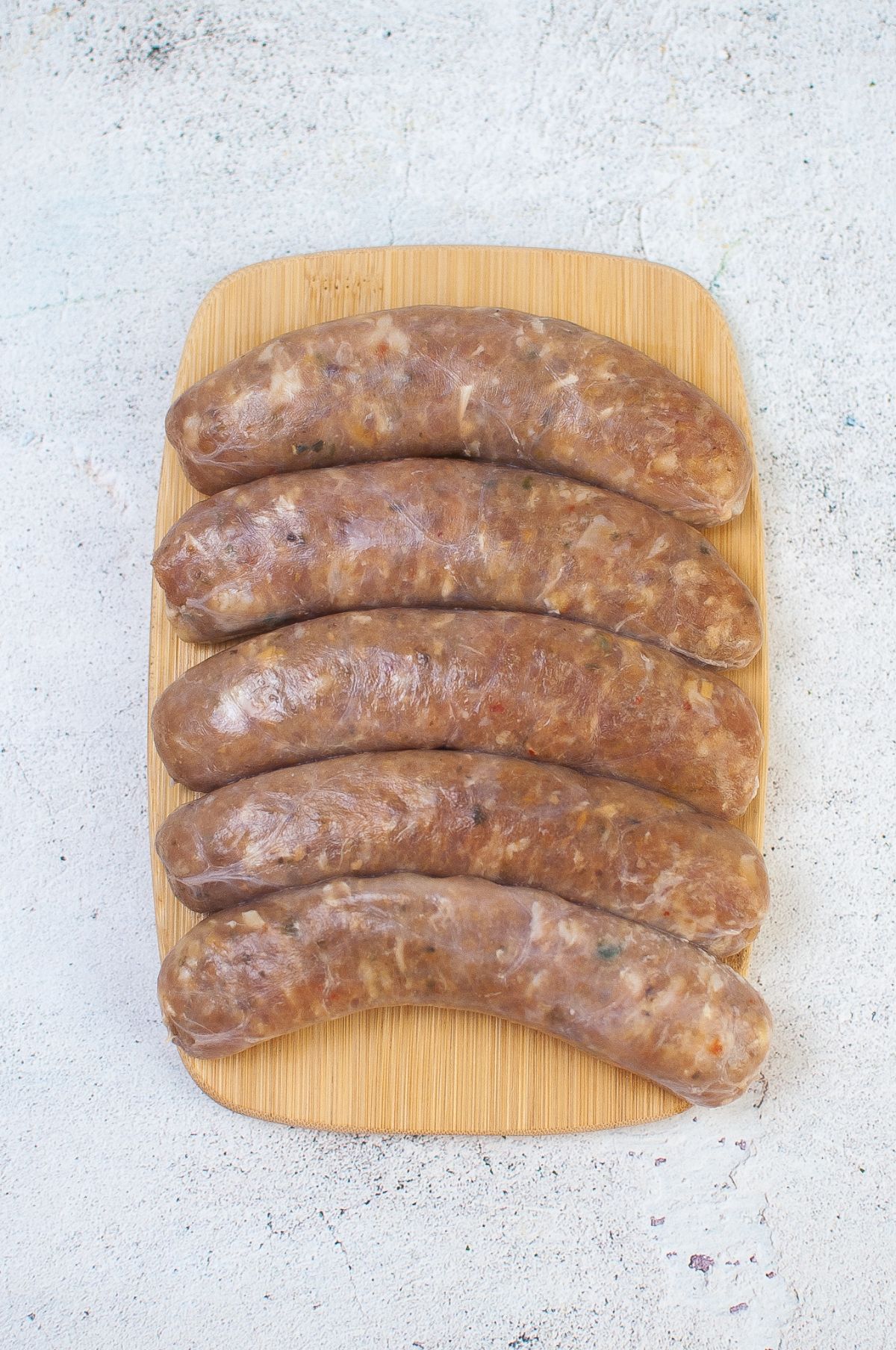 Air Fryer Sausage ingredients on a wooden board.