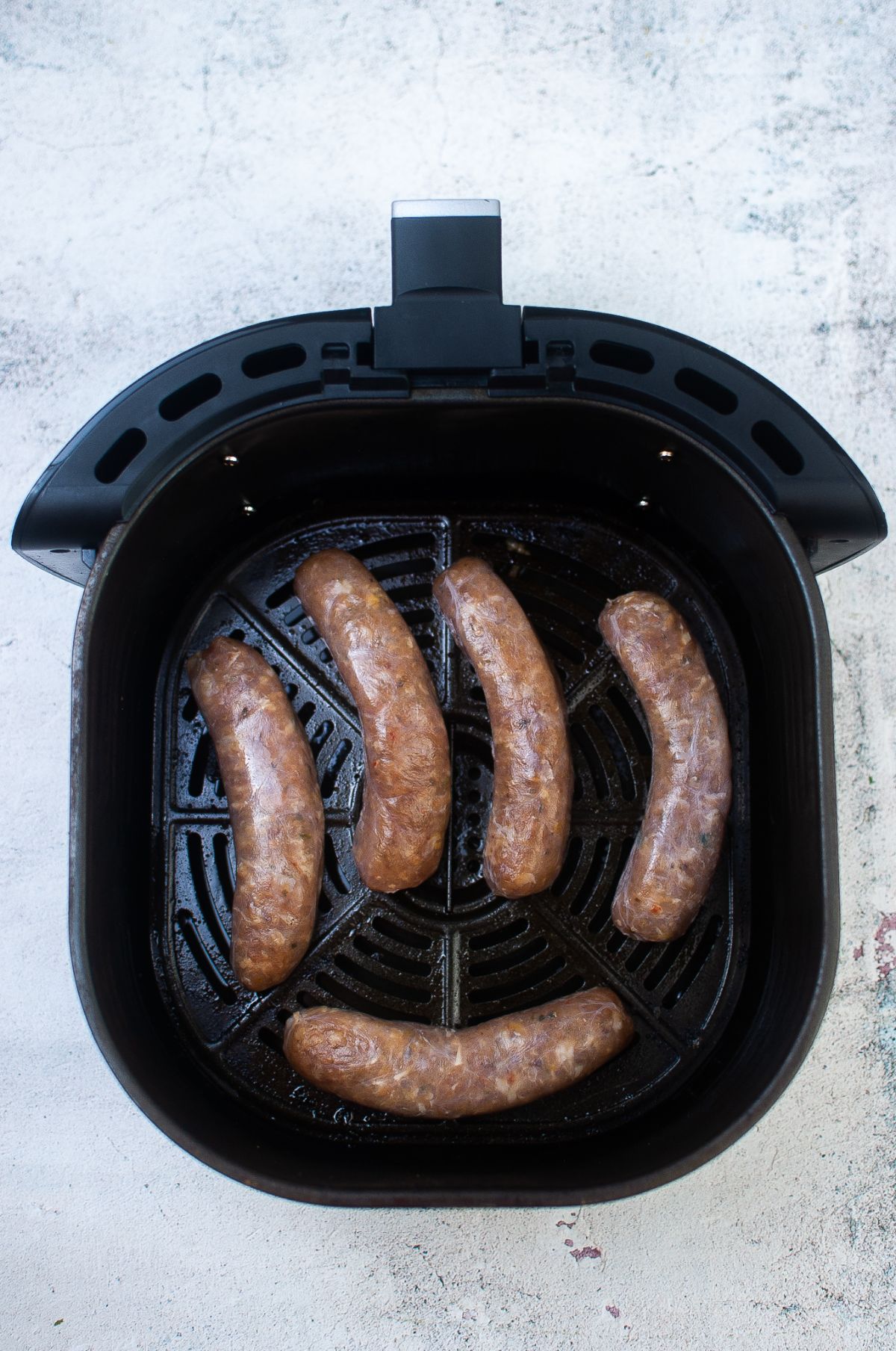 Five sausages inside the Air Fryer.