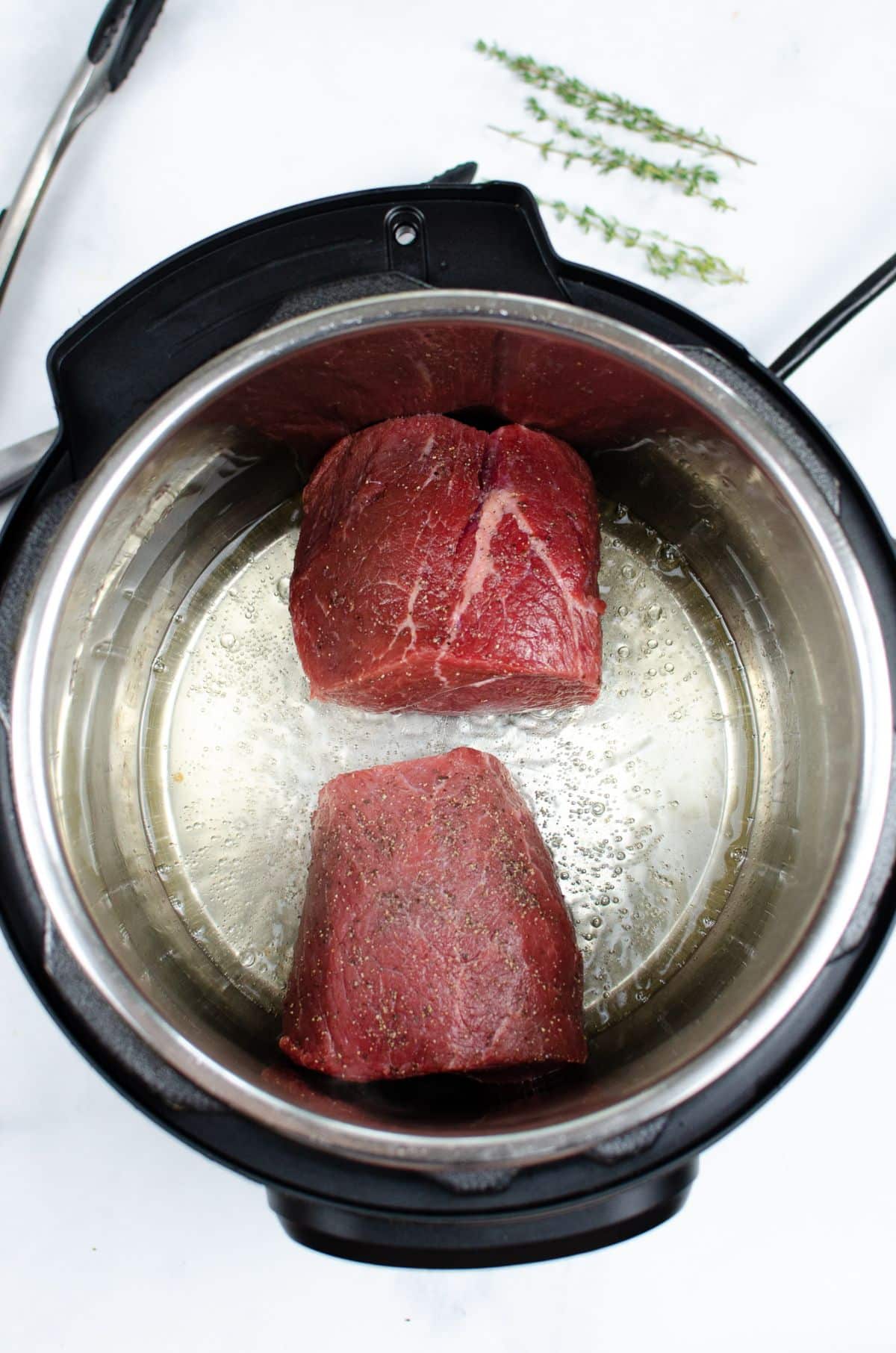 Oil and beef roast in the pressure cooker.