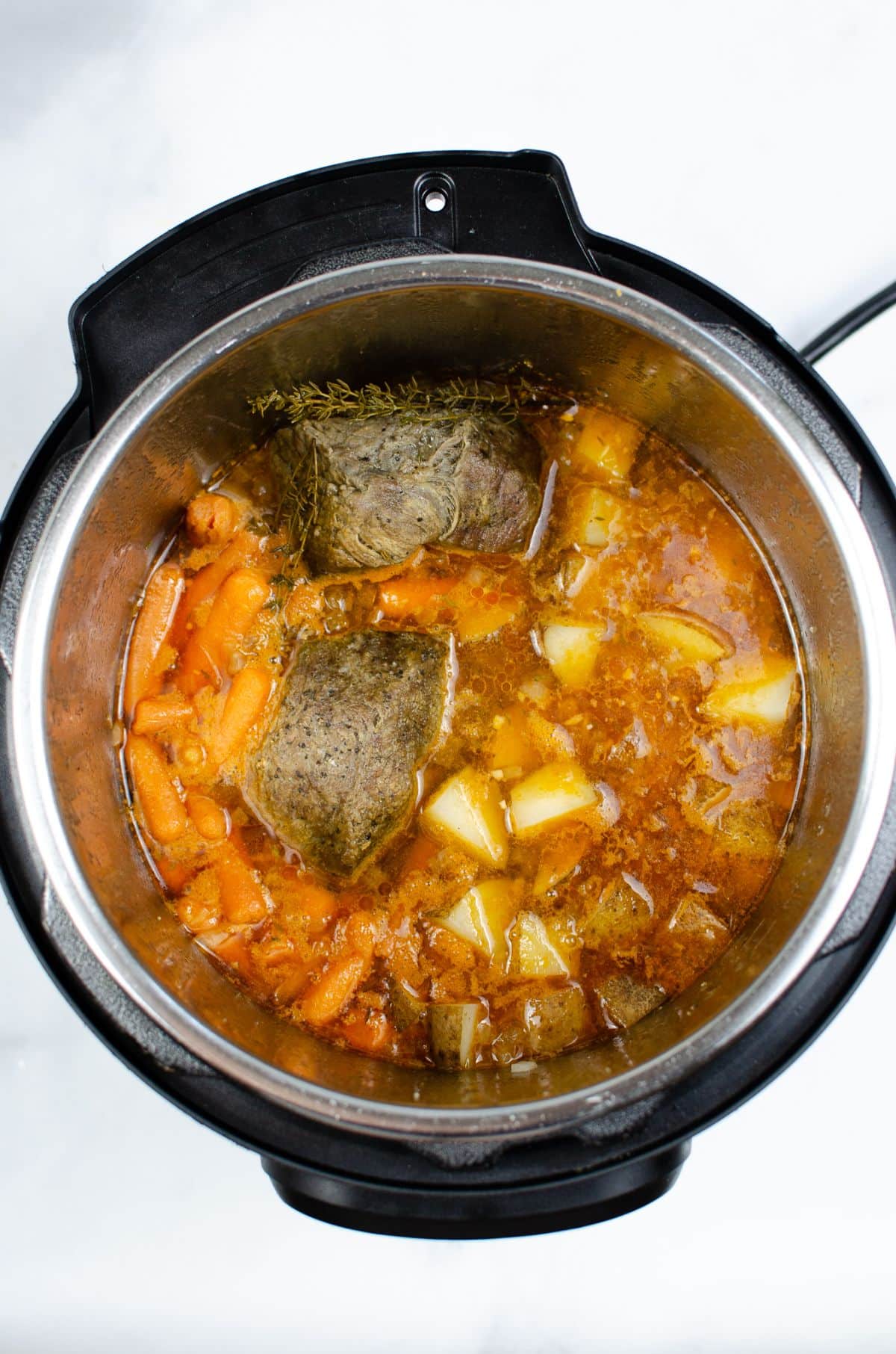 the meat and vegetables being cooked in the instant pot.