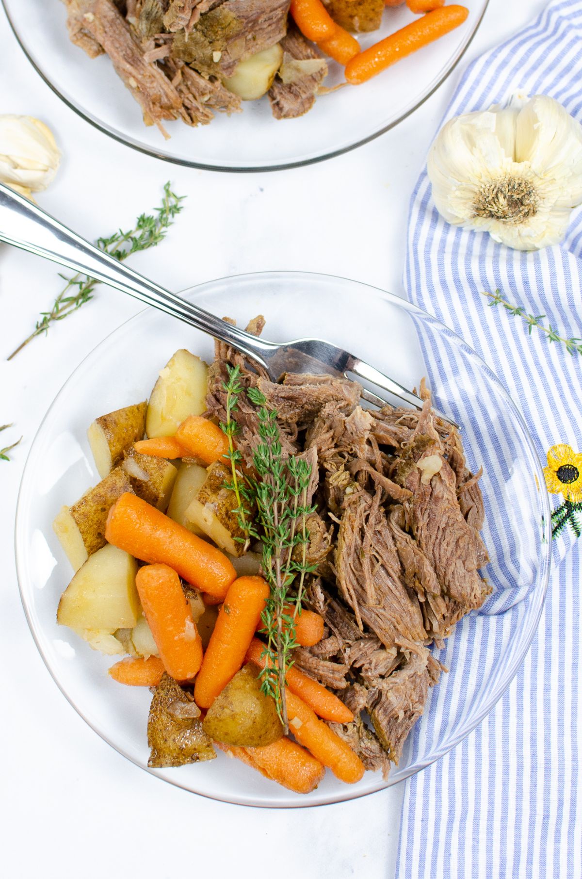 Instant Pot Roast With Potatoes and Carrots on a serving plate, garnished with fresh thyme.