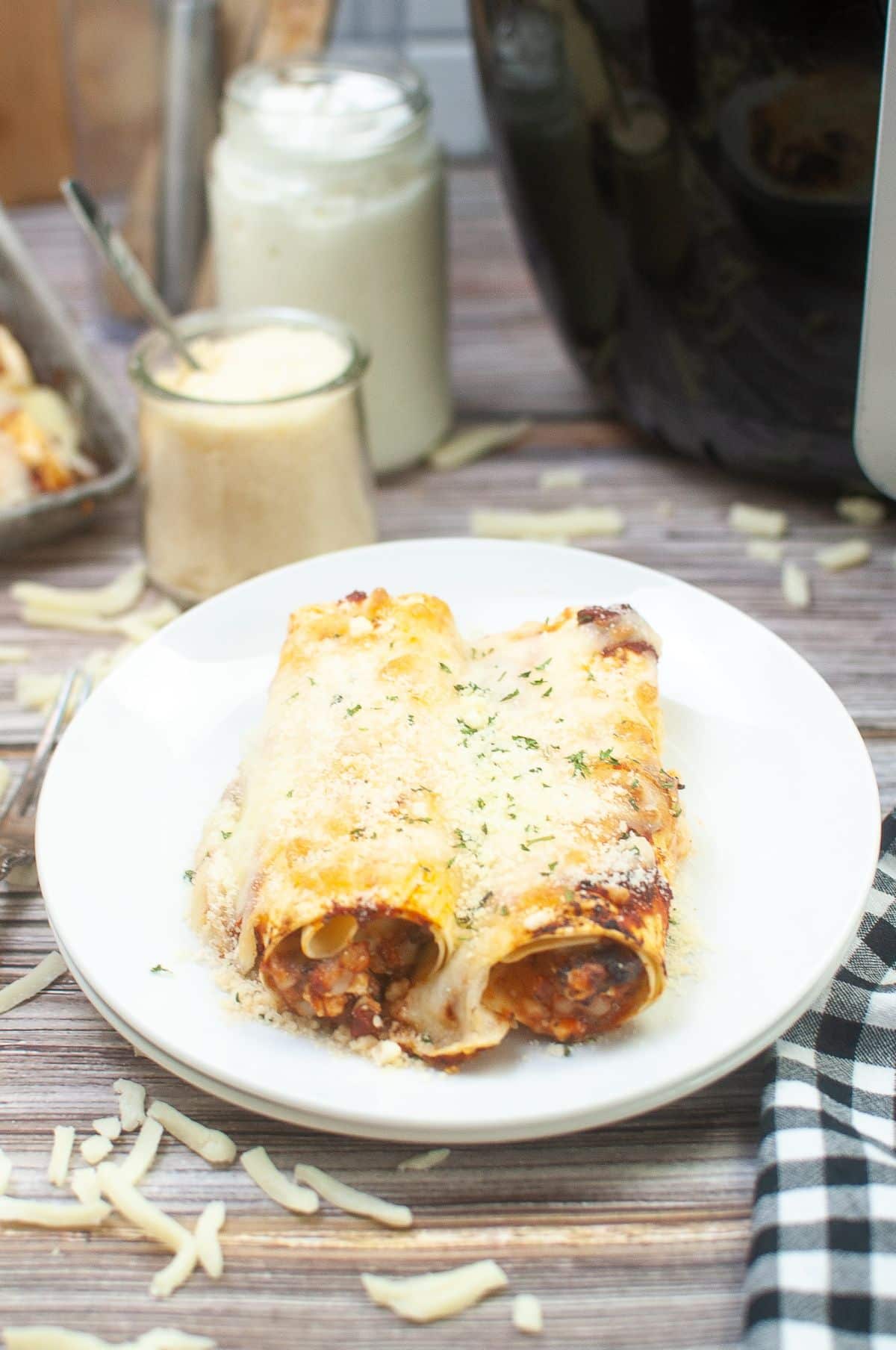 Air Fryer Lasagna Rolls on a plate, garnished with parmesan and parsley.