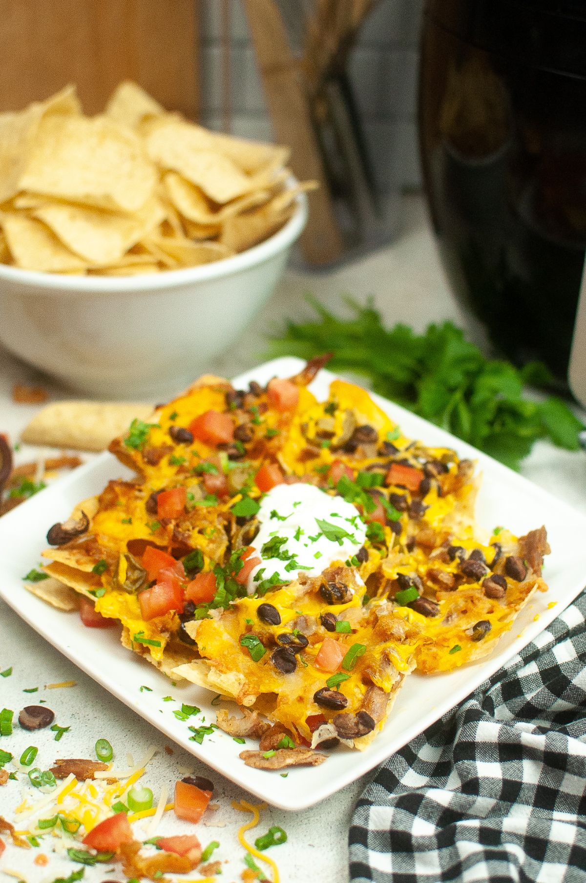 Air Fryer Nachos on a serving plate., topped with a dollop of sour cream.