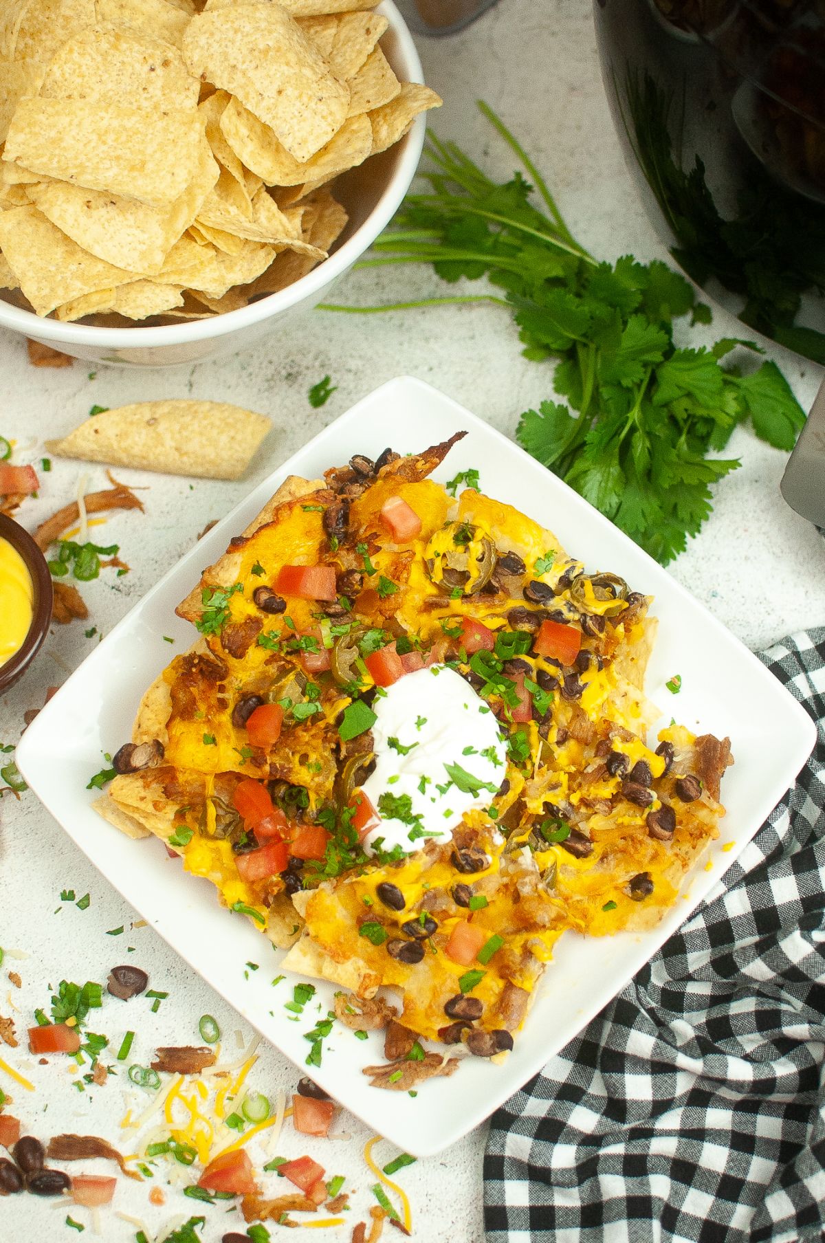 Air Fryer Nachos on a serving plate., topped with a dollop of sour cream.