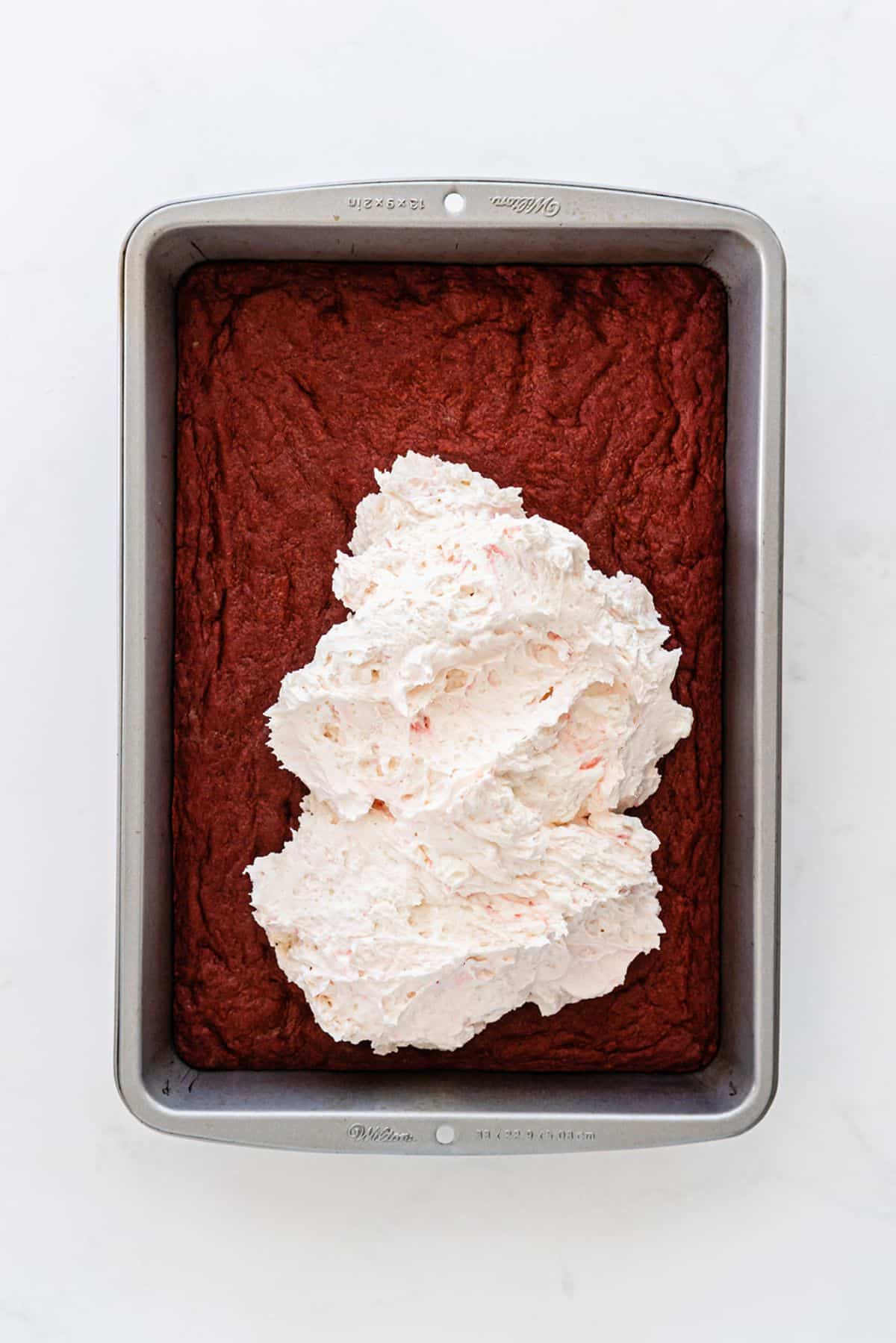 The cream cheese mixture is spread on top of the brownies.
