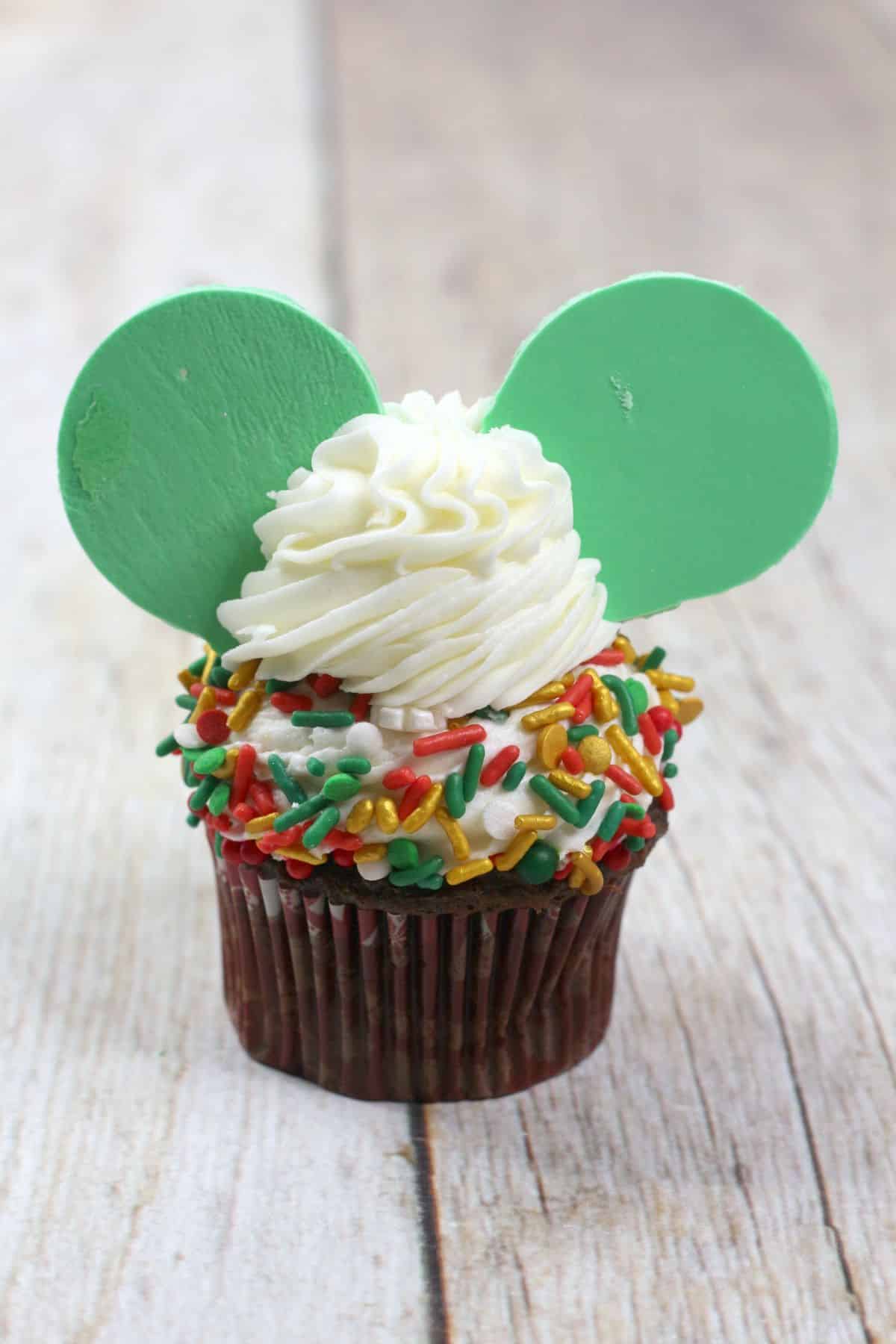The mini mouse ears are added on the top of the cupcake with frosting.