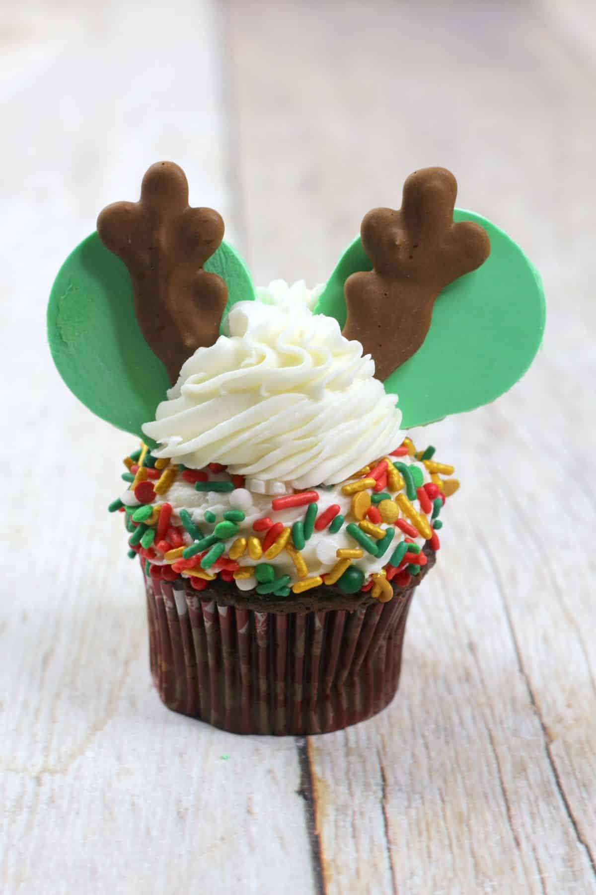 The antlers are added on the top of the frosting on the cupcake.