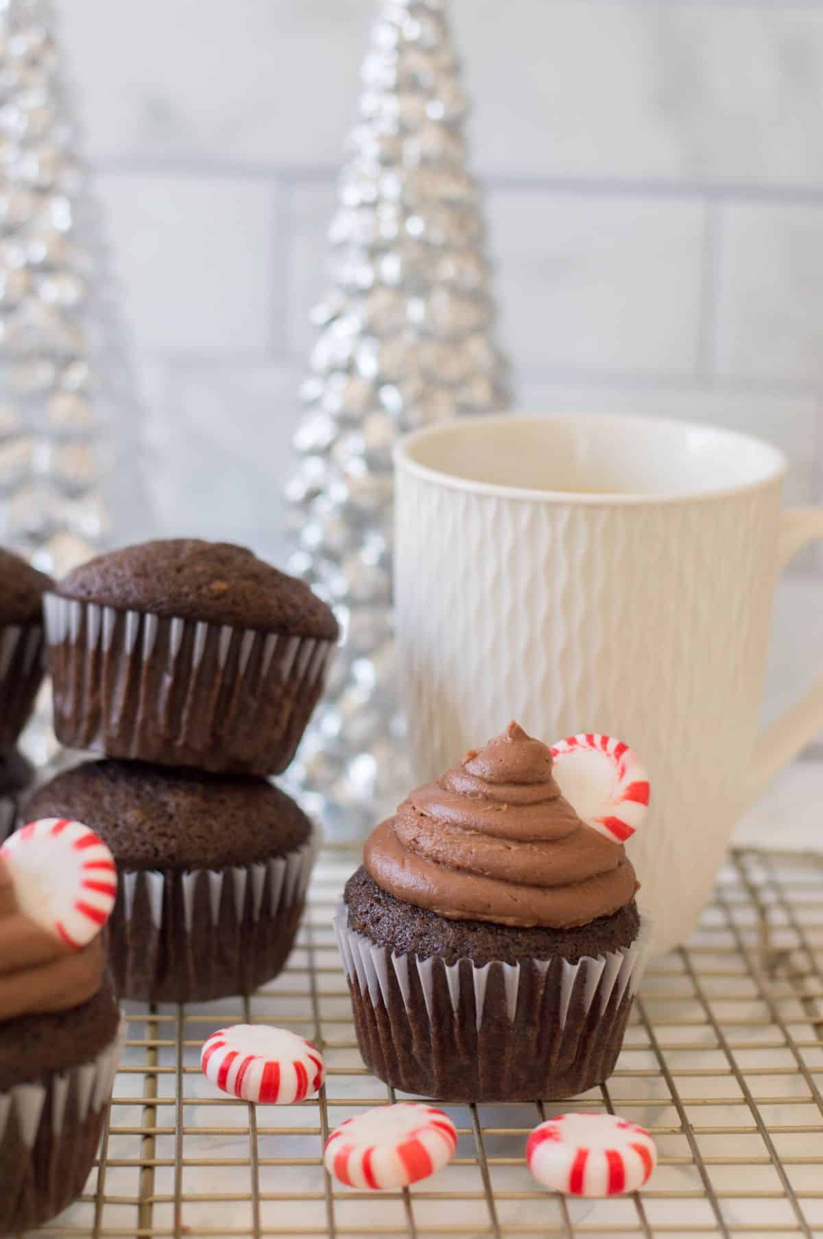 Peppermint Mocha Cupcakes on a baking rack, topped with peppermint candy.
