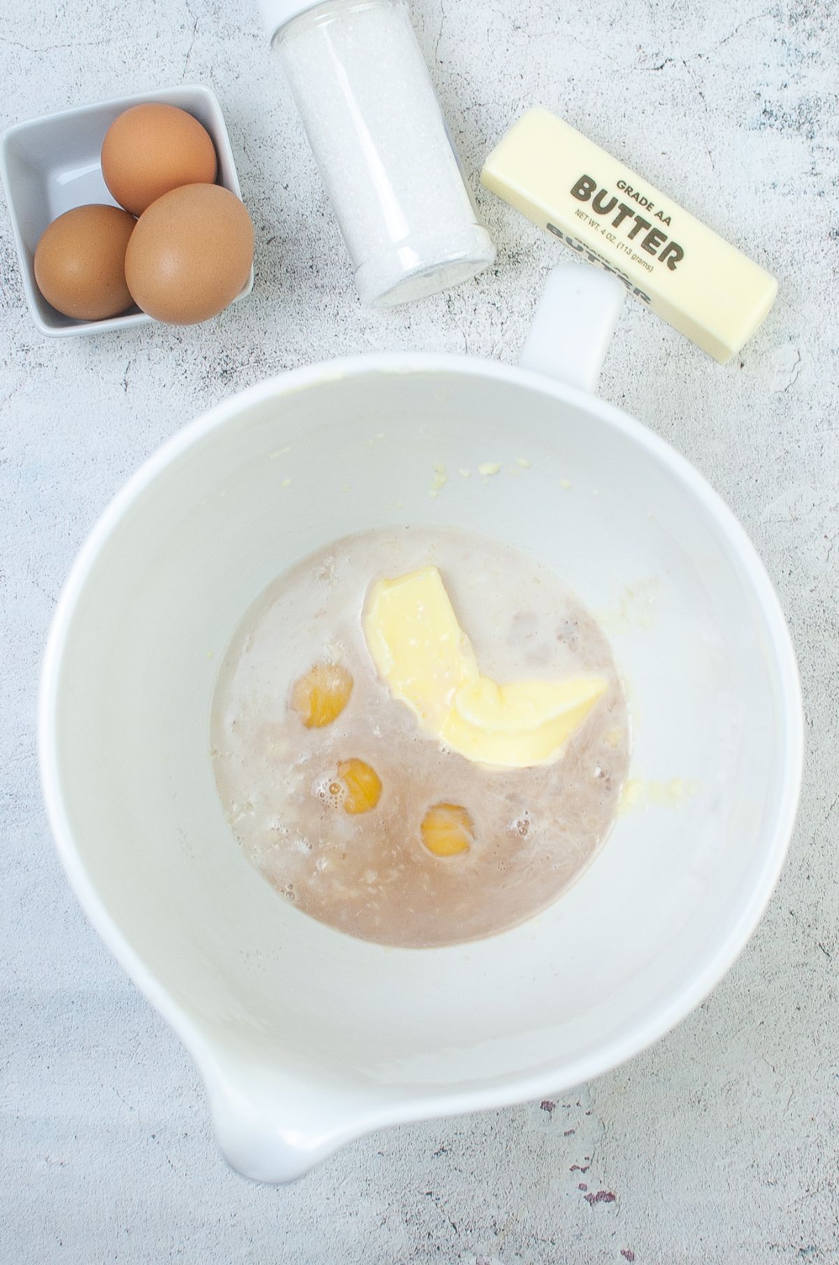 Melted butter, milk, eggs and vanilla extract in a mixing bowl.