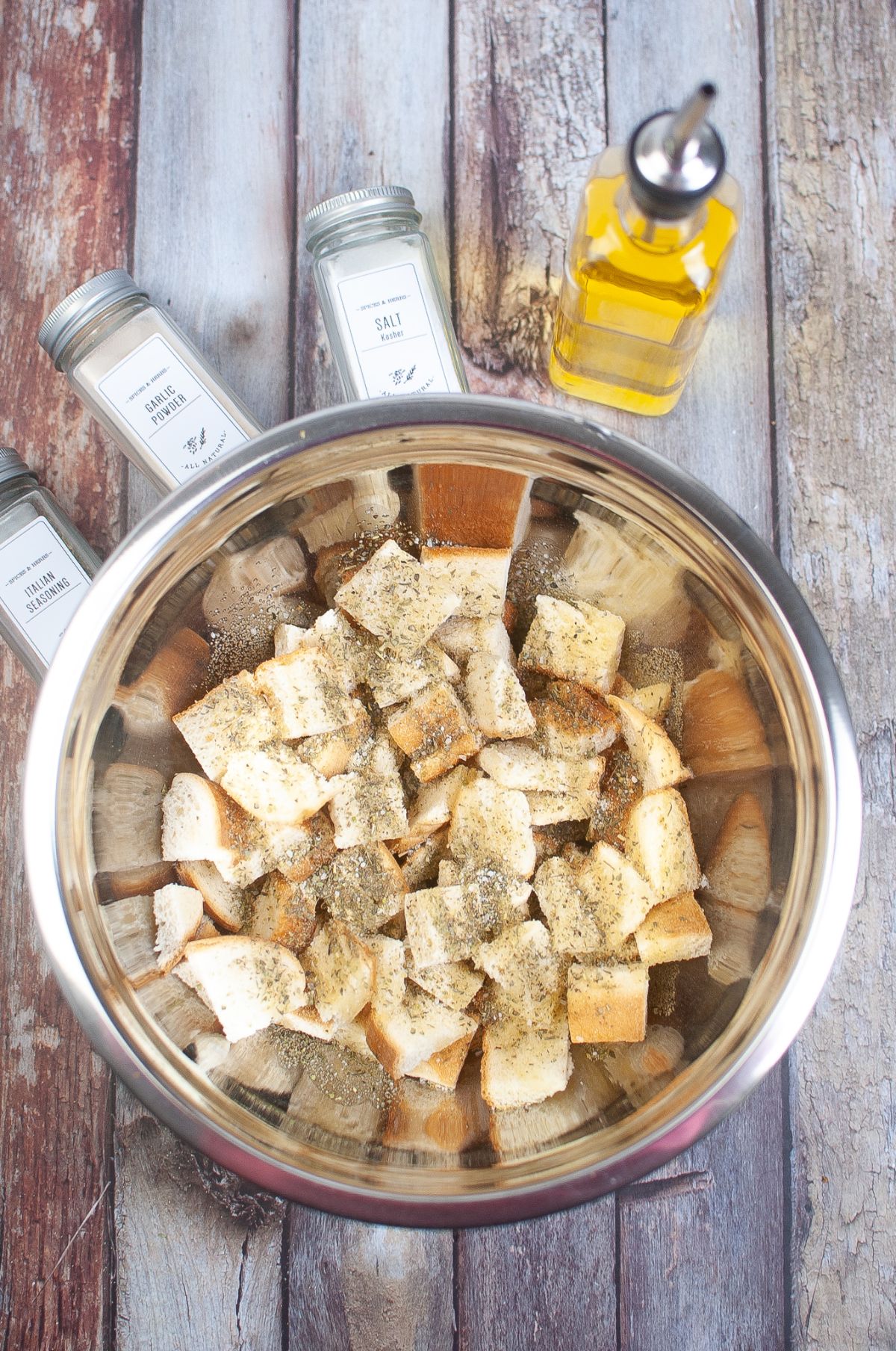 Cubed bread and seasonings in a large mixing bowl.