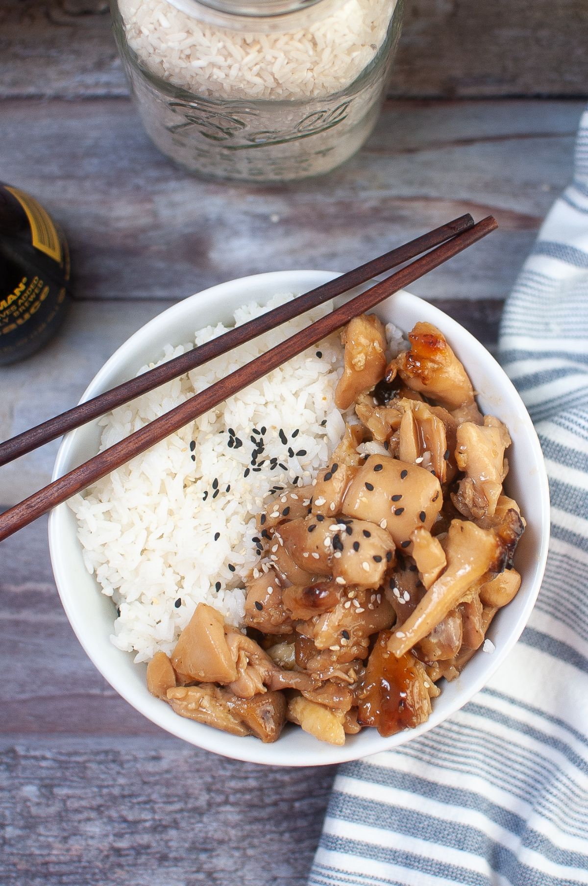 Air Fryer Teriyaki Chicken in a bowl, topped with sesame seeds with chopsticks on the side.