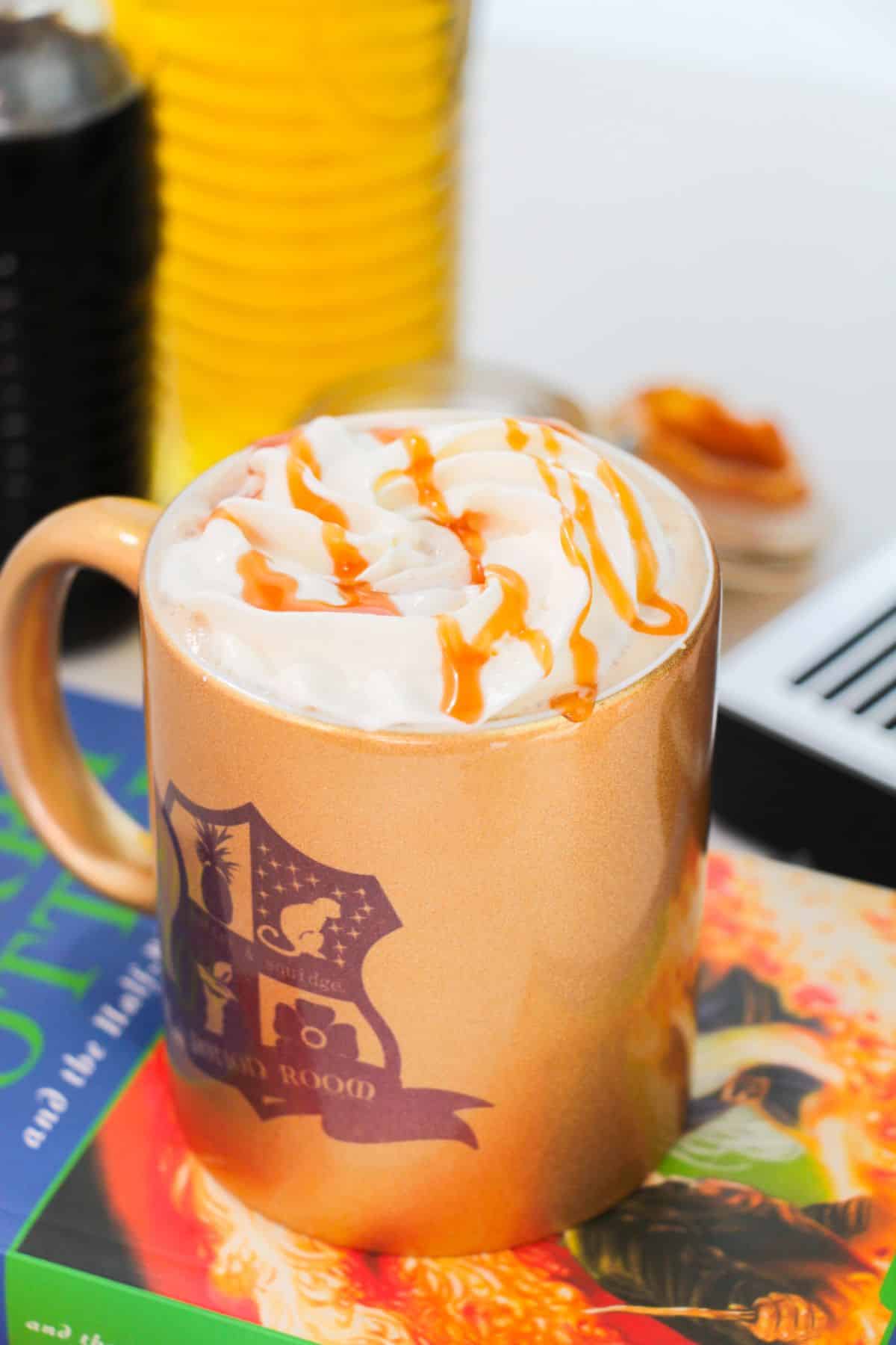 Butterbeer Latte in a mug with caramel drizzle on the top.