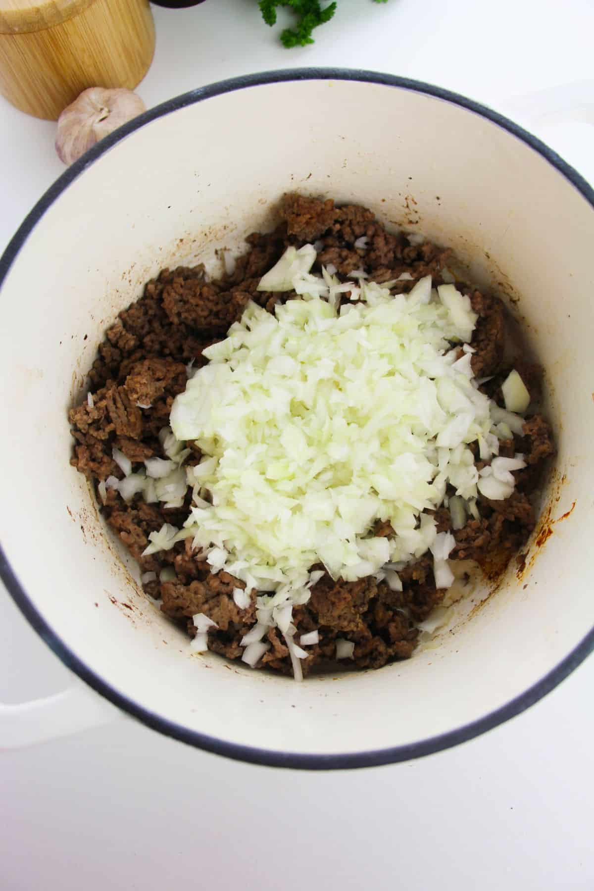 Onion and garlic are added to the ground beef.