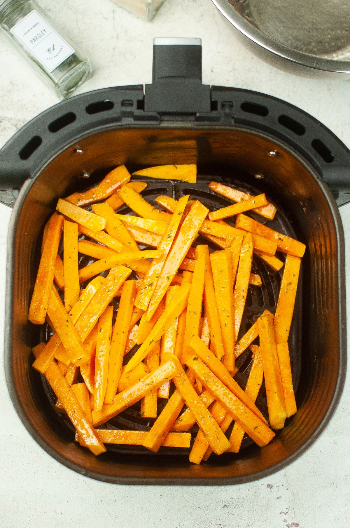 Squash fries in the air fryer basket.