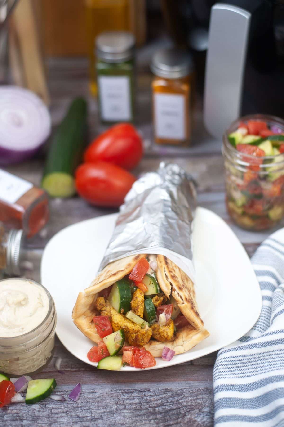 Chicken Shawarma on a serving plate, with ingredients and Air Fryer on the side.