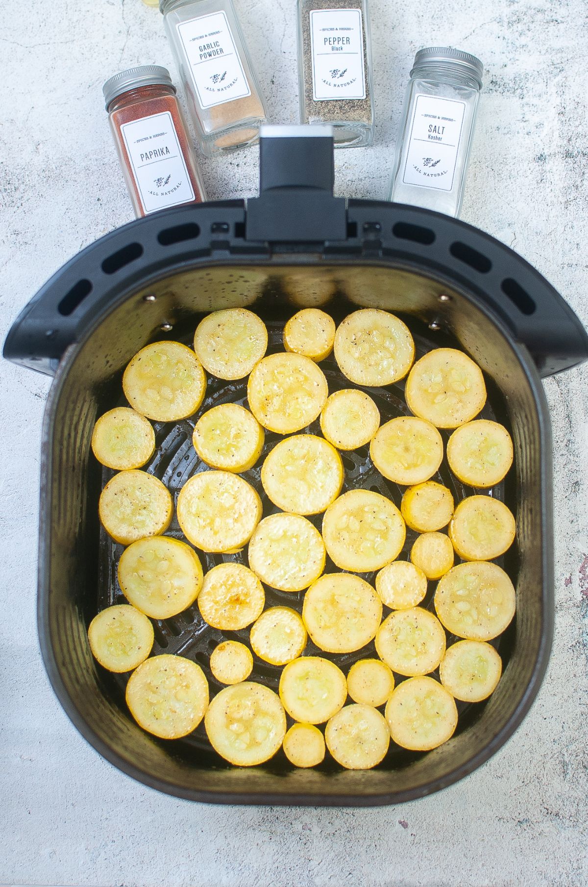 Slices of squash in the air fryer basket.
